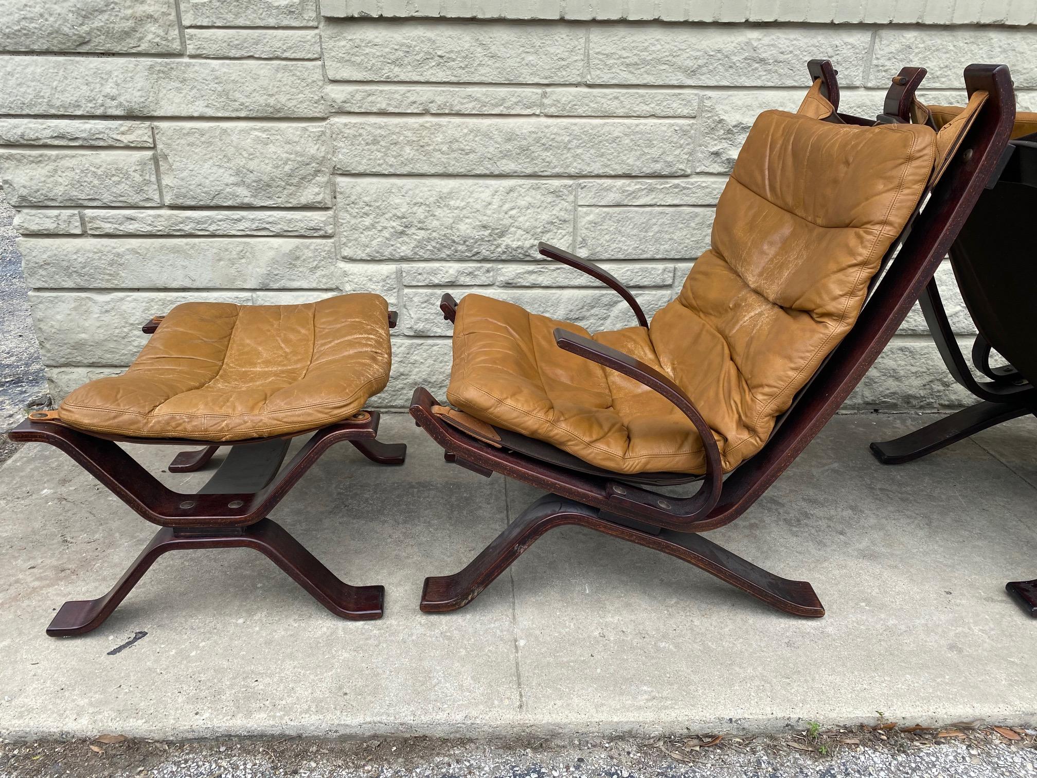 Pair of vintage Danish Focus armchair in light brown leather, wooden frame with ottoman foot-stool are in good condition. Bramin worked with many respected designers, producing a wide range of visually appealing modern furniture for the home and