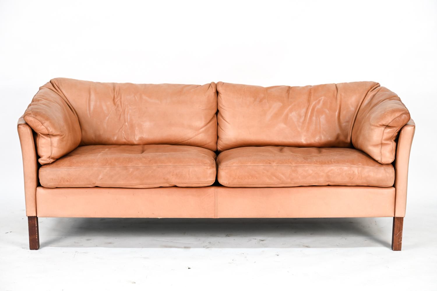 A stylish pair of Danish mid-century sofas by Mogens Hansen upholstered in handsomely patinated brandy leather.