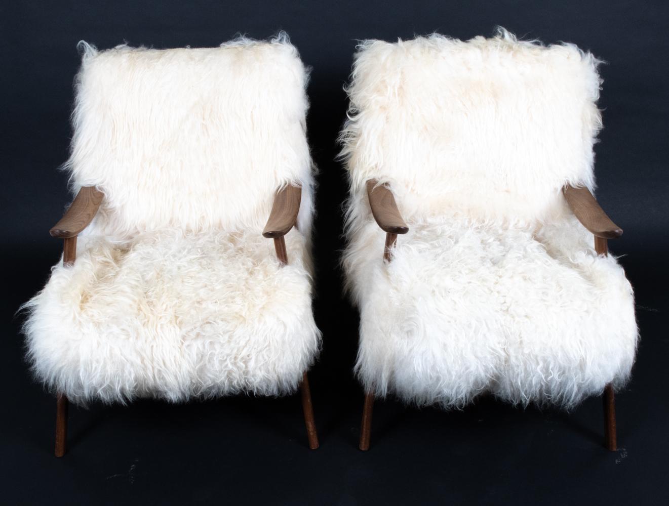 Relax in sheer bliss with this rare and exquisite pair of Danish mid-century easy chairs and footstools. Upholstered in shaggy, plush white Mongolian sheepskin, these chairs provide a lap of luxury to sink into with matching ottomans to kick your