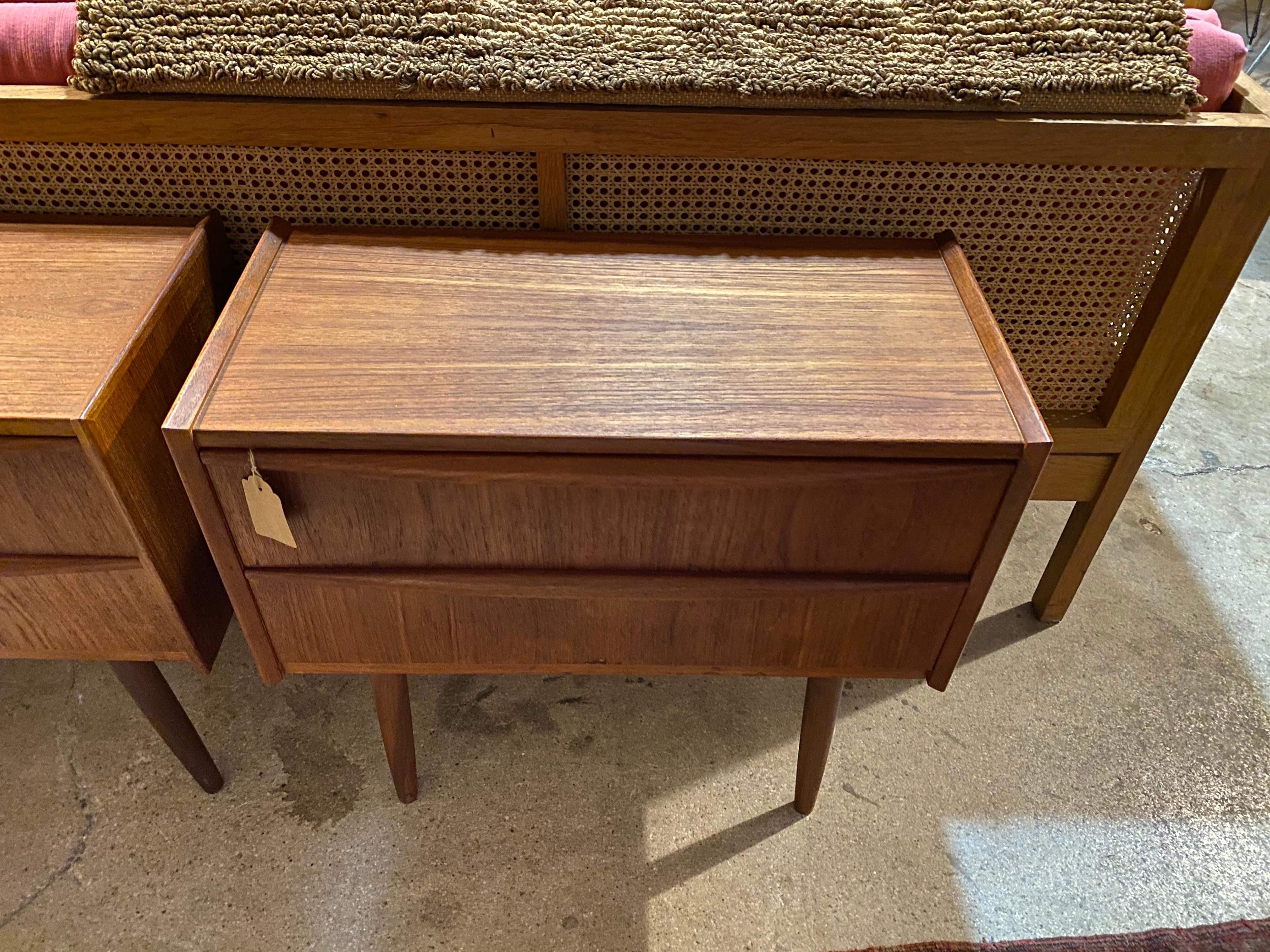 Pair of mid-century Danish teak nightstands features two drawers and beautifully carved pull handles. This set is in great overall condition.