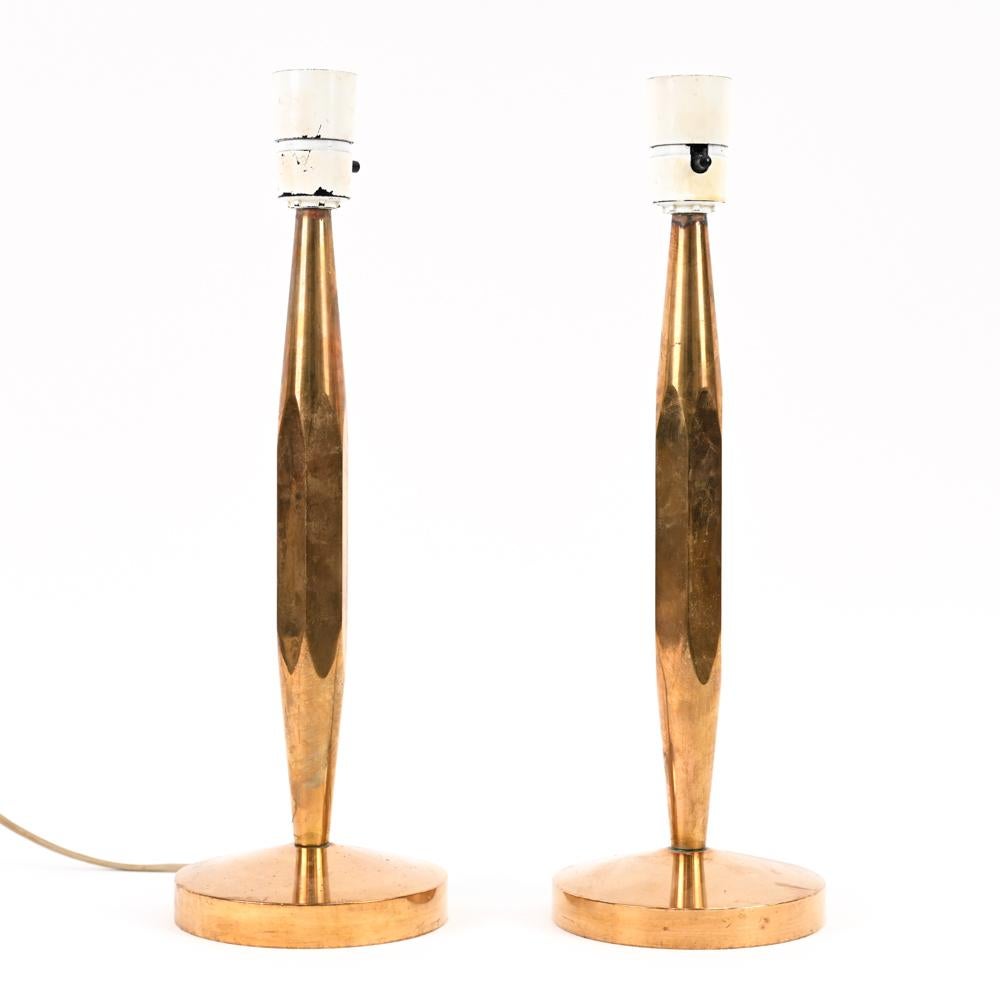 A pair of heavy, solid Danish mid-century candlestick-form faceted brass table lamps. These minimalist design lamps make them quite the versatile pair.
No manufacturer's markings.