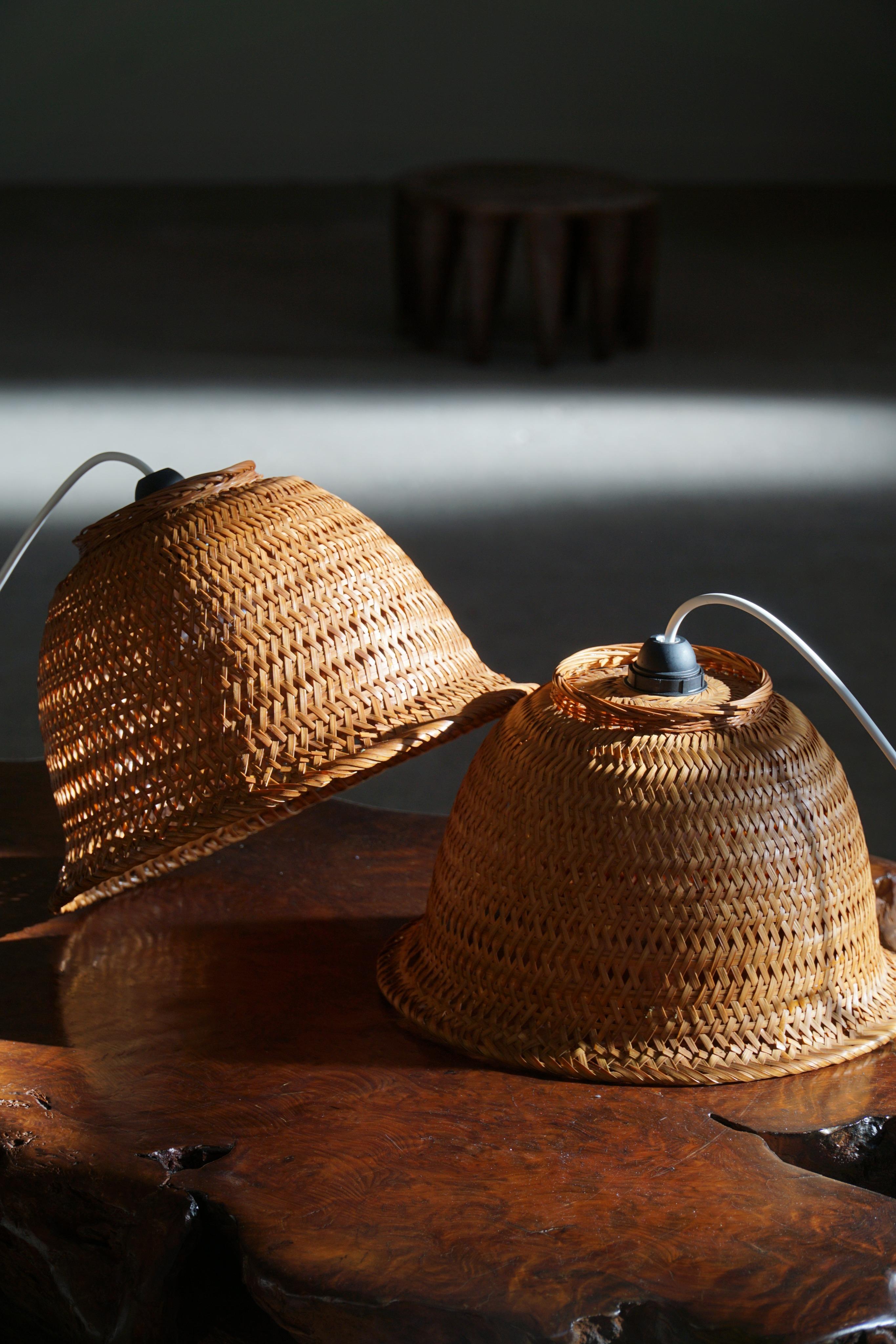 A welcoming and pleasant pair of pendant lights in wicker / rattan. Made by a Danish cabinetmaker in 1960s. These pendants give a calm and cosy light to your home. A beautiful object that pairs well with many types of interior styles. A Modern,