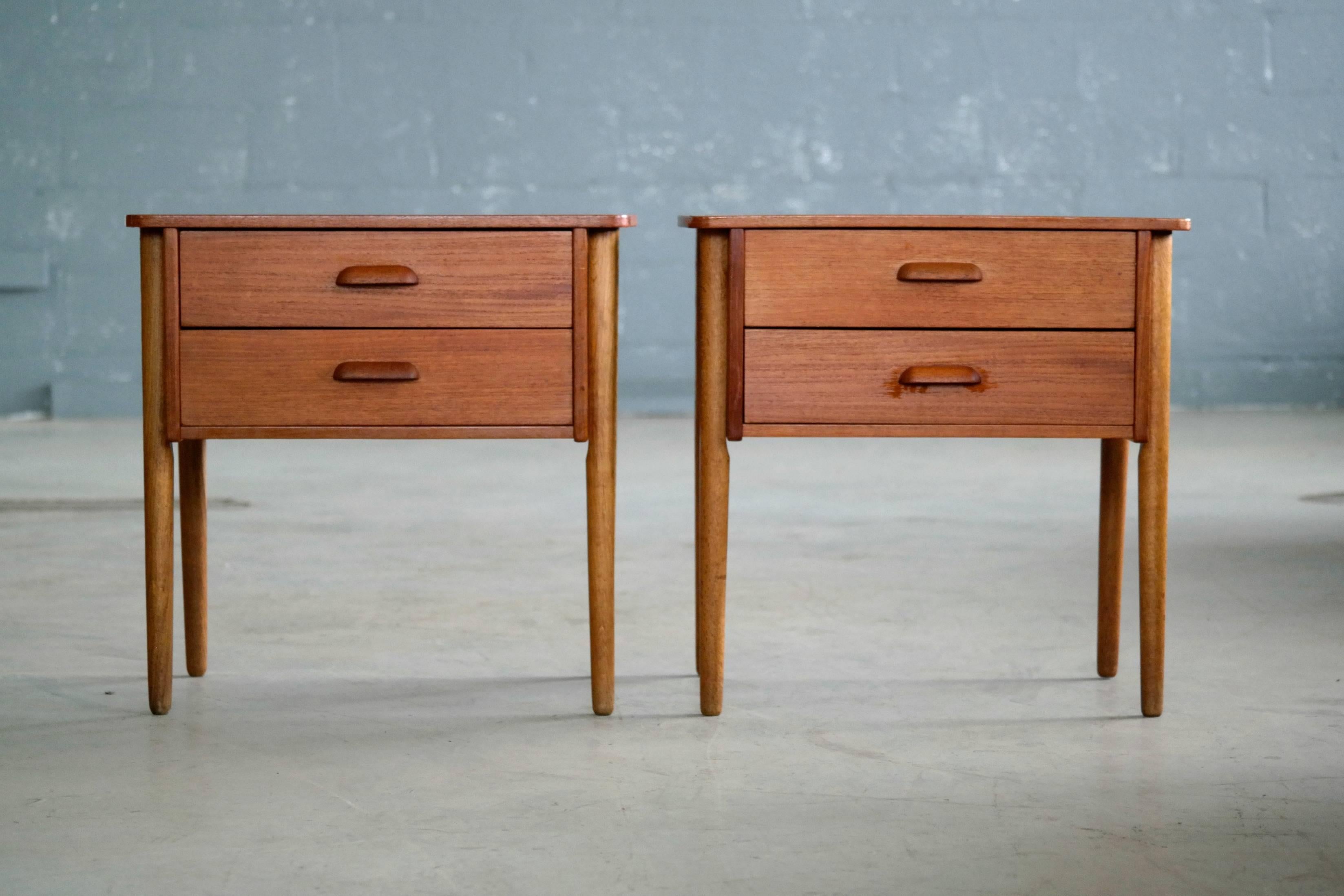 Elegant pair of nightstands made from teak veneer on legs of solid oak. Nice build quality all solid ply with nice dovetailing of drawers. Great grain and color with only minor age appropriate wear. Unmarked.