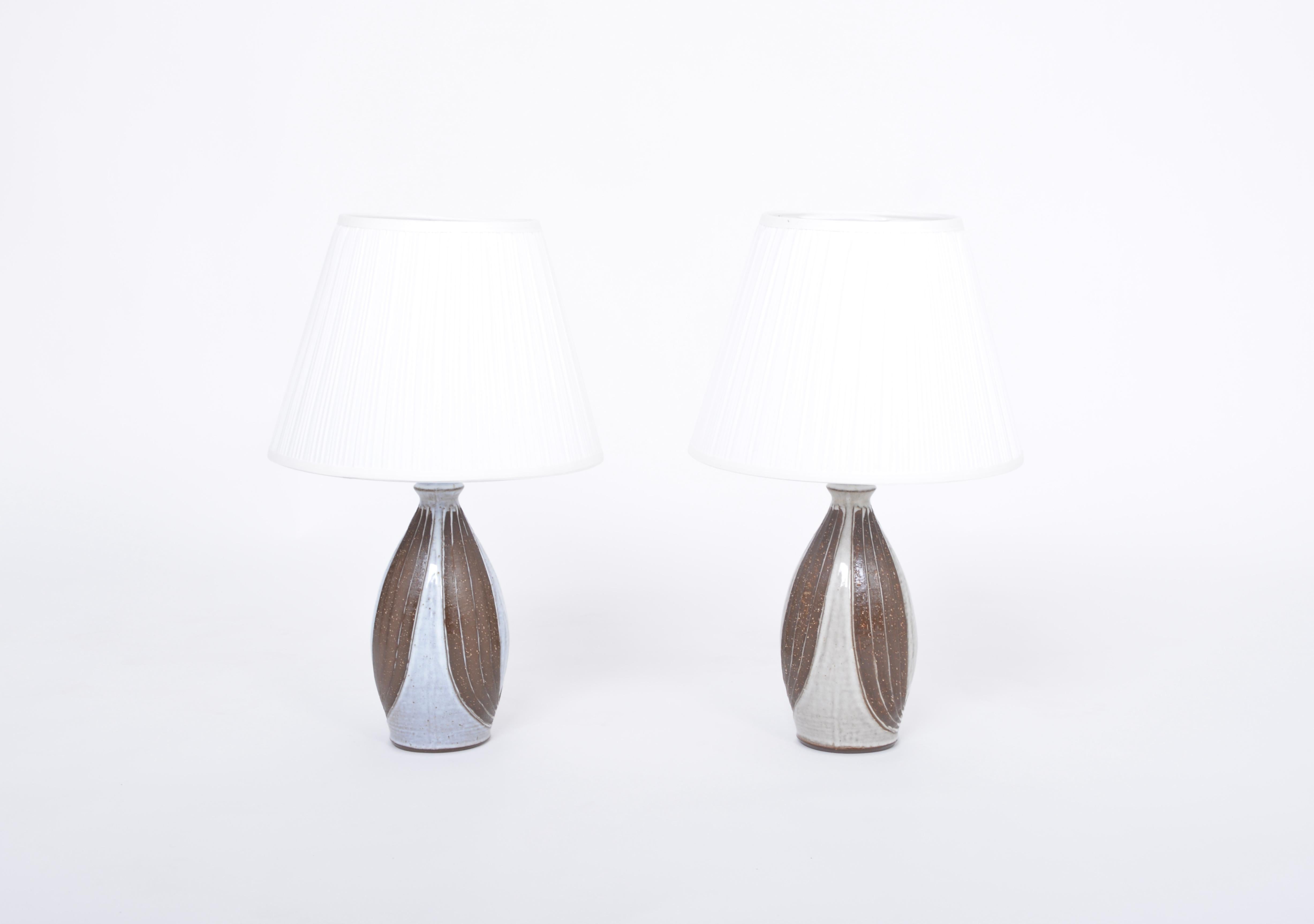 Pair of Danish midcentury table lamps by Michael Andersen 
This pair of table lamps was produced by Michael Andersen & Søn in the 1960s.
Beautiful sculpturally shaped base with brown and white / grey colored glaze. The base have an onion like