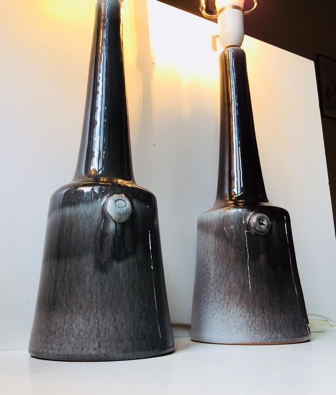 This matching pair of large and long-necked Danish Studio Pottery table lights have been finished with black and grey drip and hare's fur glazing techniques. The pieces were manufactured and designed by Holbæk Keramik in Denmark during the 1960s.