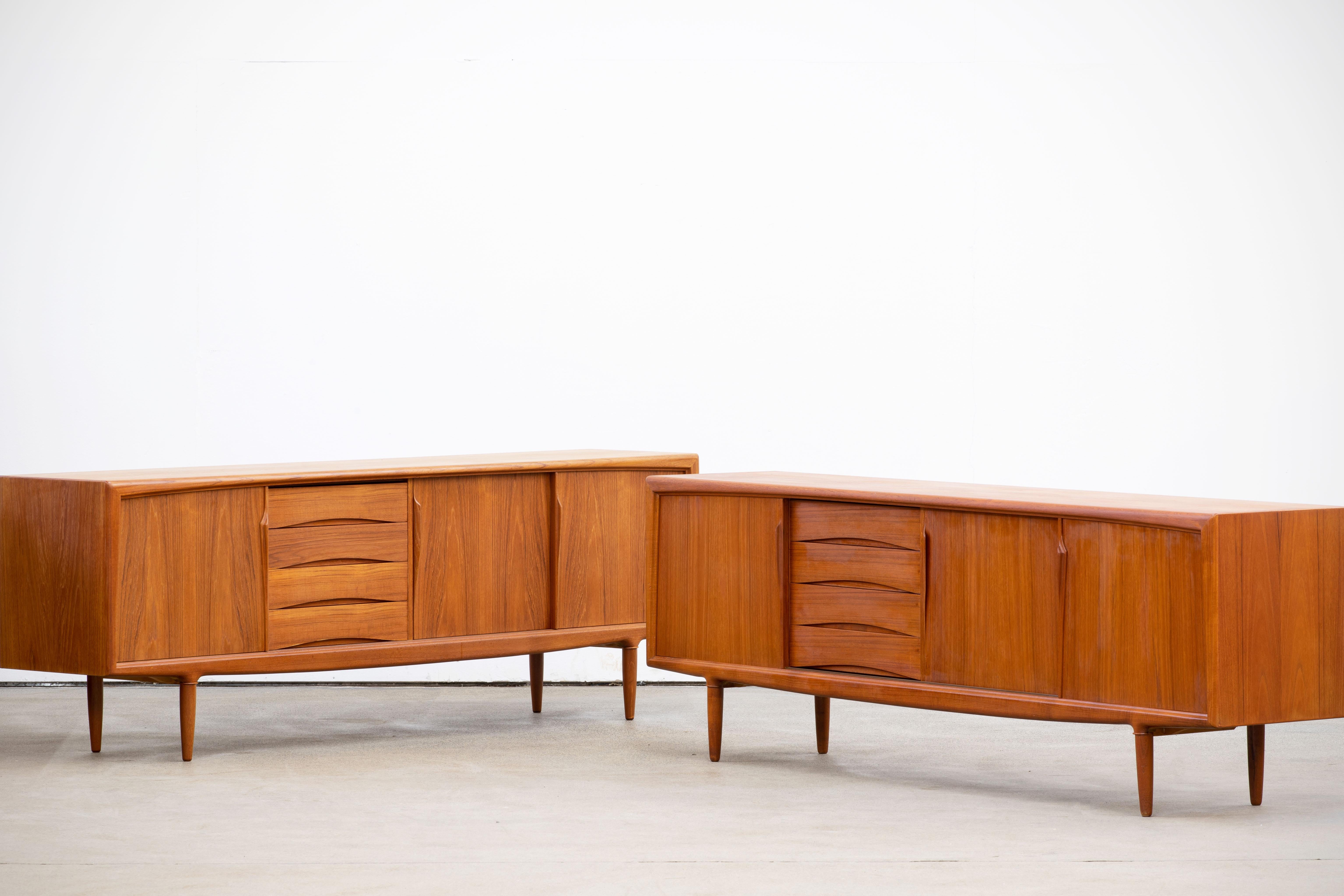 Stunning pair of midcentury designed by Gunni Omann teak sideboards by ACO Møbler, 1960s, lovely top and sliding doors, fully lined (four) drawers and stands on nice solid teak legs (this is the very scarce model that has the round legs without the