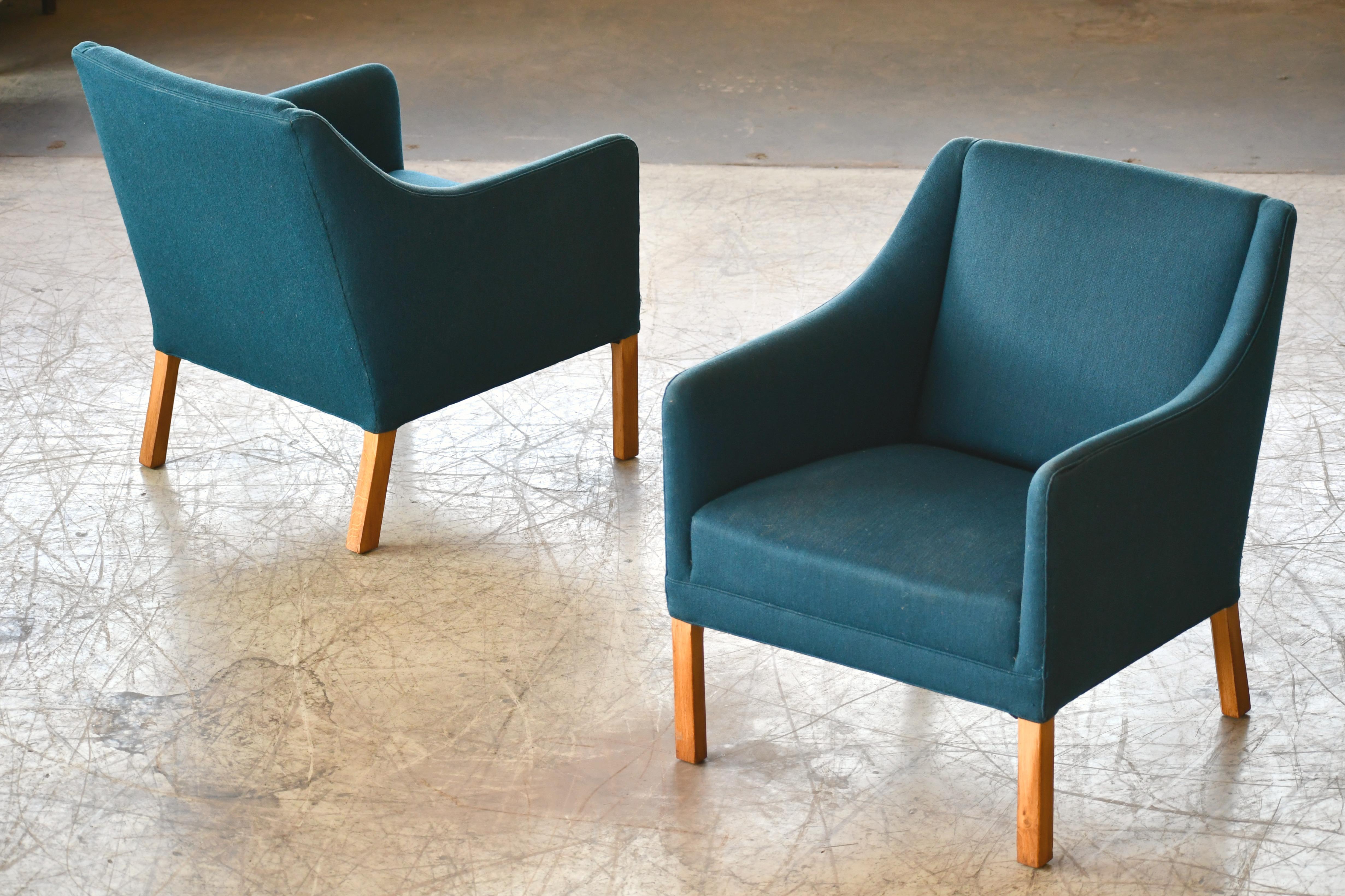 Elegant pair of Classic Danish lounge chairs attributed to the famous design duo Ejnar Larsen & Axel Bender Madsen. Simple yet refined lines raised on legs of solid oak. Solid and sturdy and in overall very good condition with the wool fabric in