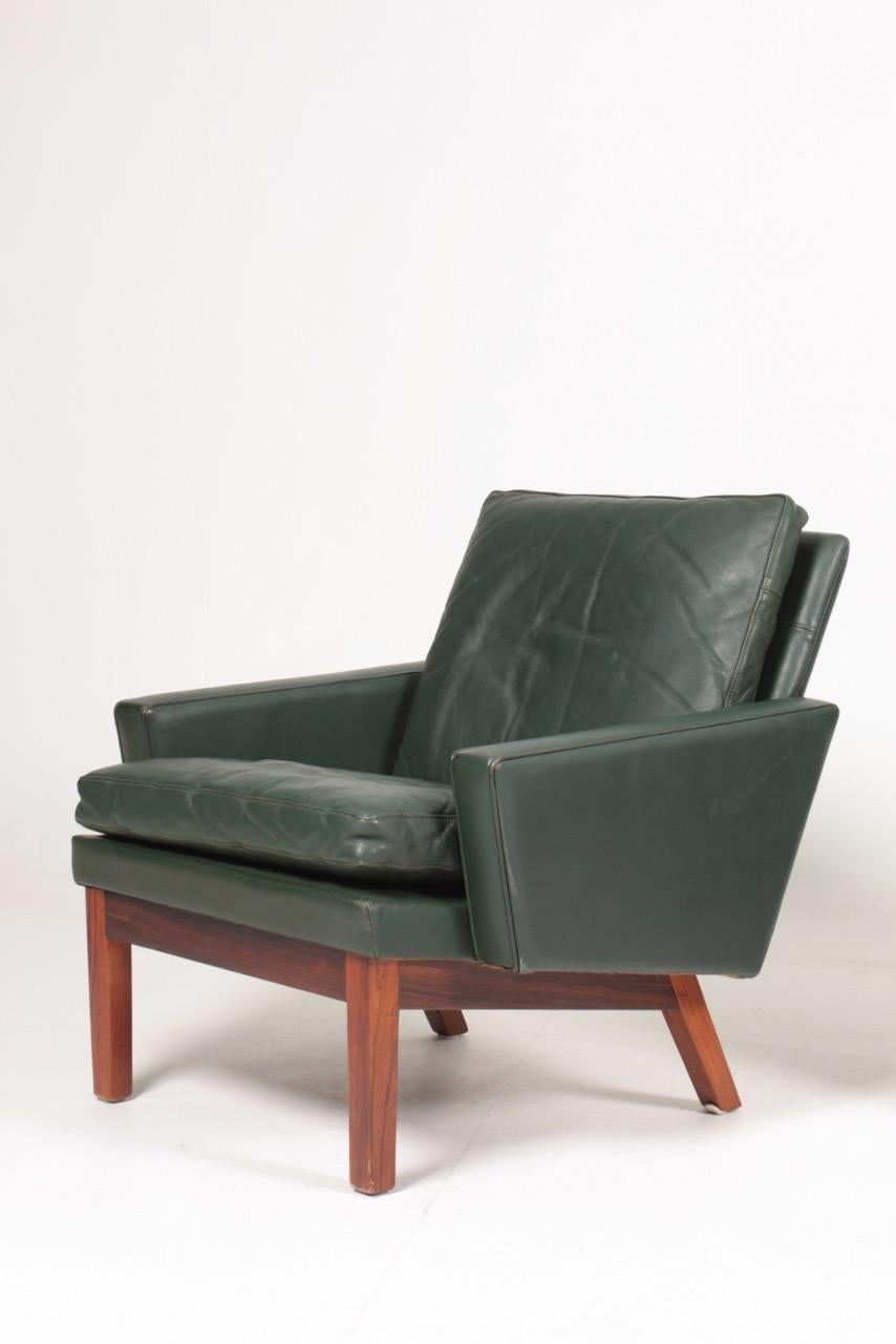 Pair of lounge chairs in patinated leather and rosewood frame, designed and made in Denmark. Great original condition.