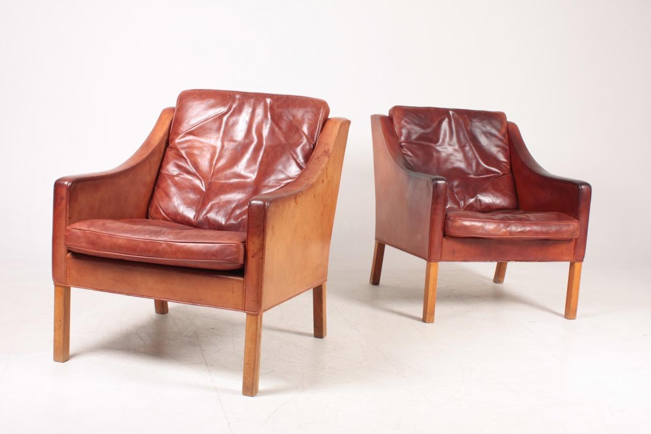 Pair of lounge chairs in patinated leather designed by MAA. Børge Mogensen for Fredericia Møbelfabrik. Outstanding quality and very comfortable. Great original condition.