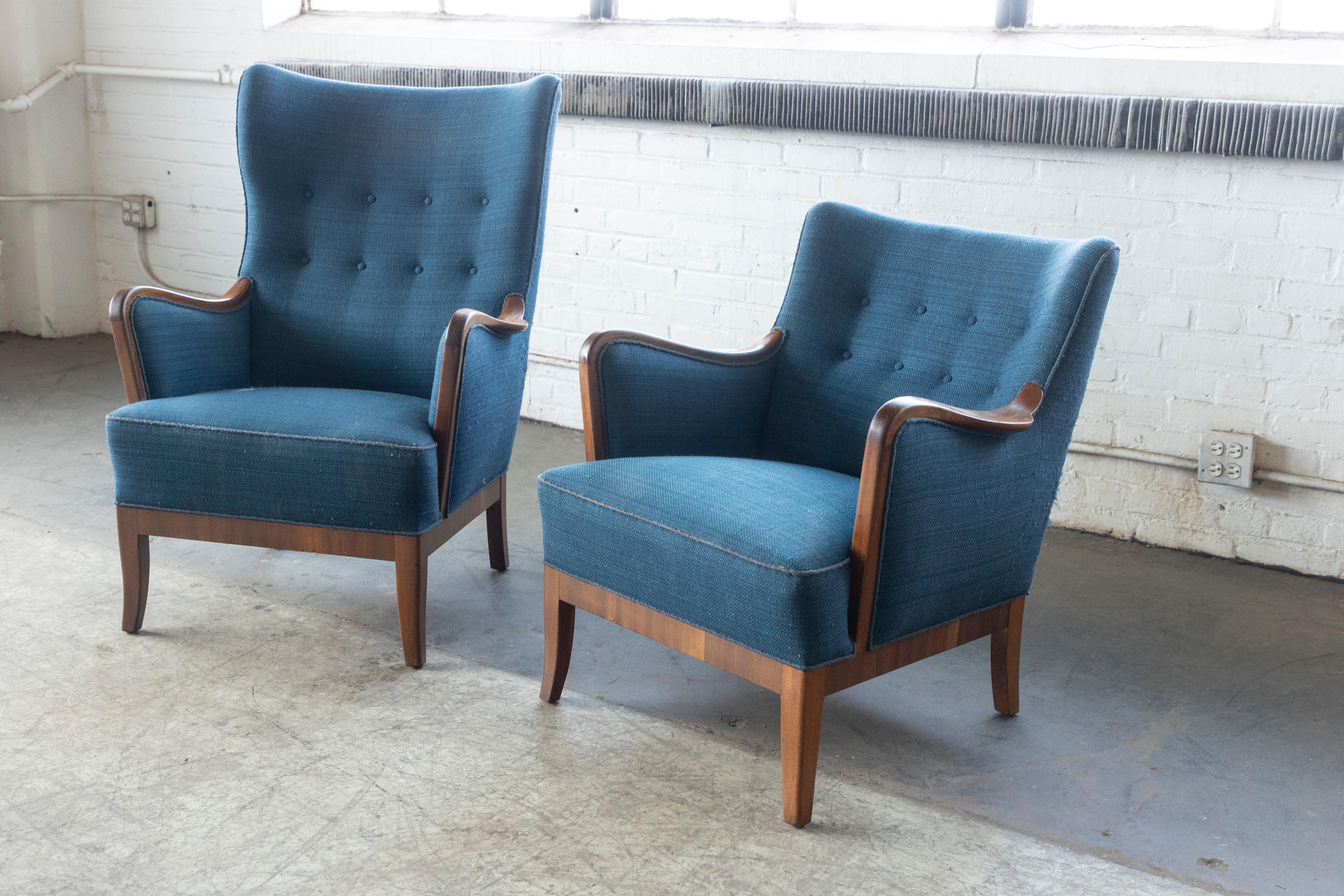 Very elegant and charming lounge chairs in his and hers style with walnut wood accents on the armrest and bottom frame and legs also in walnut. Very high quality craftmanship and finish. We are not familiar with the designer and maker of these