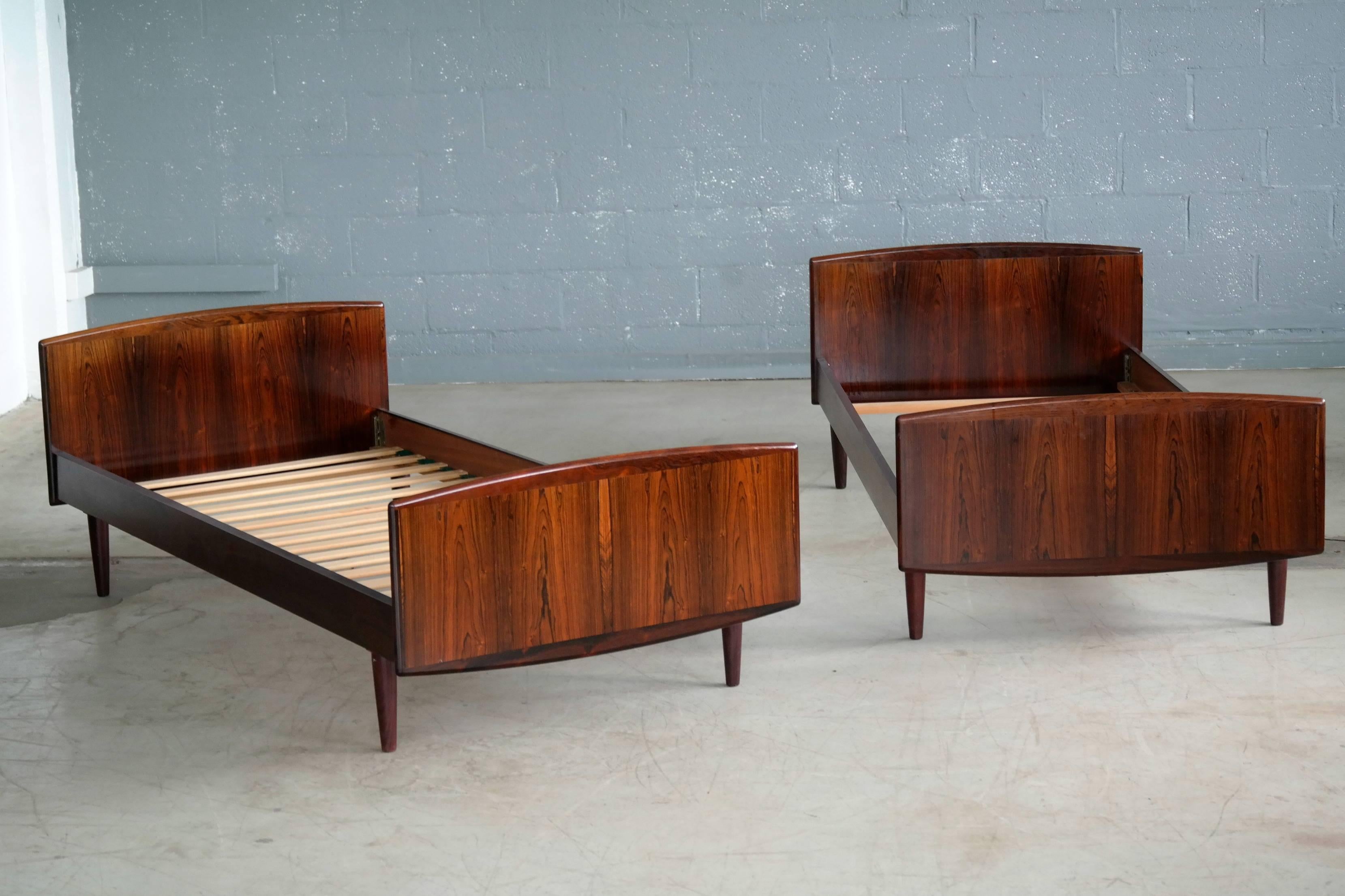 Elegant simple yet very refined pair of guest beds made from beautiful book matched rosewood veneer and thick edges in solid rosewood. Made by Sannemanns Moebelfabrik in Denmark, circa late 1950s. Perfect for the guestroom. Near perfect condition
