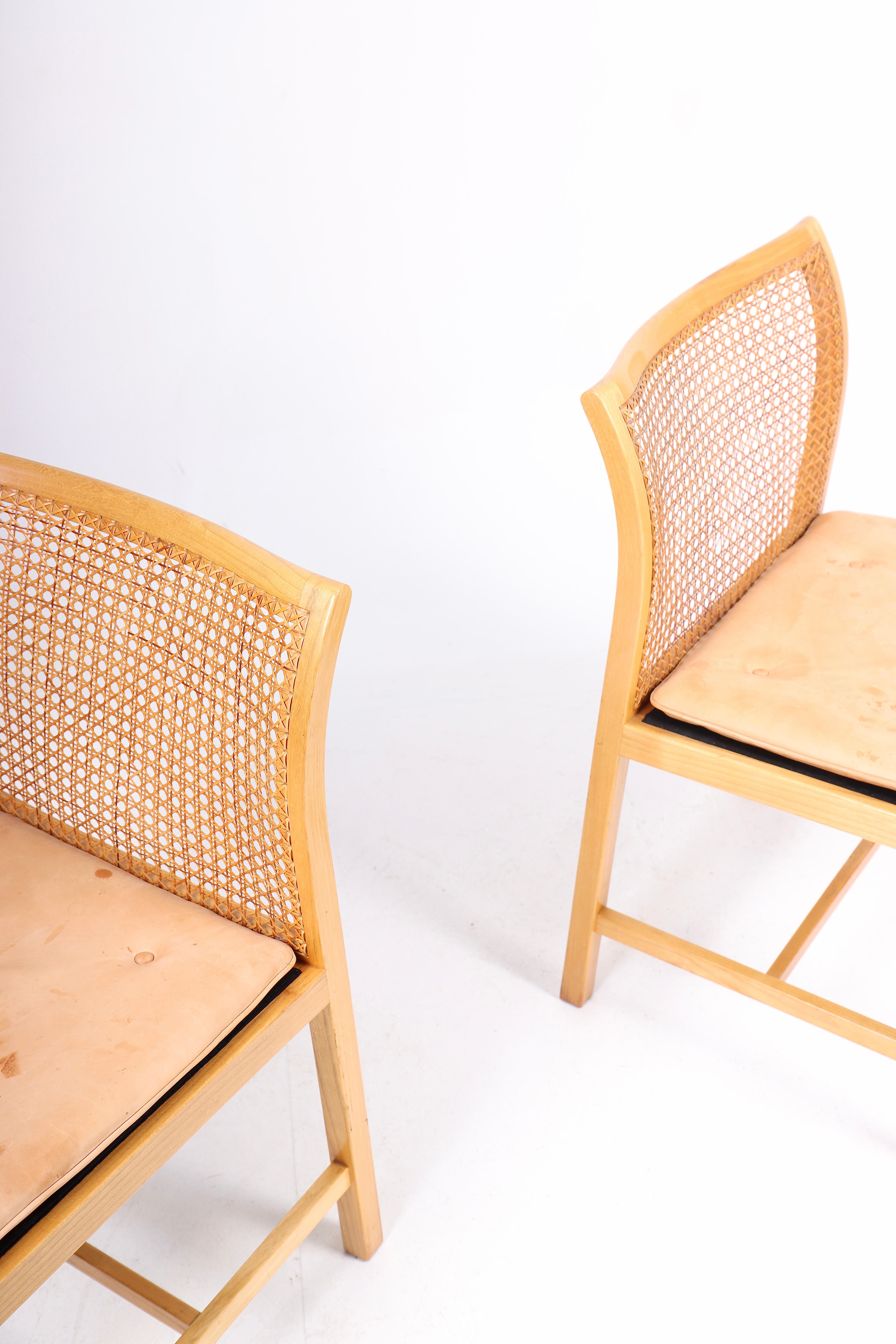 Pair of side chairs in ash, cane and patinated leather. Designed by Ditte & Adrian Heath for Søren Horn cabinetmakers. Made in Denmark in the 1960s. Great original condition.