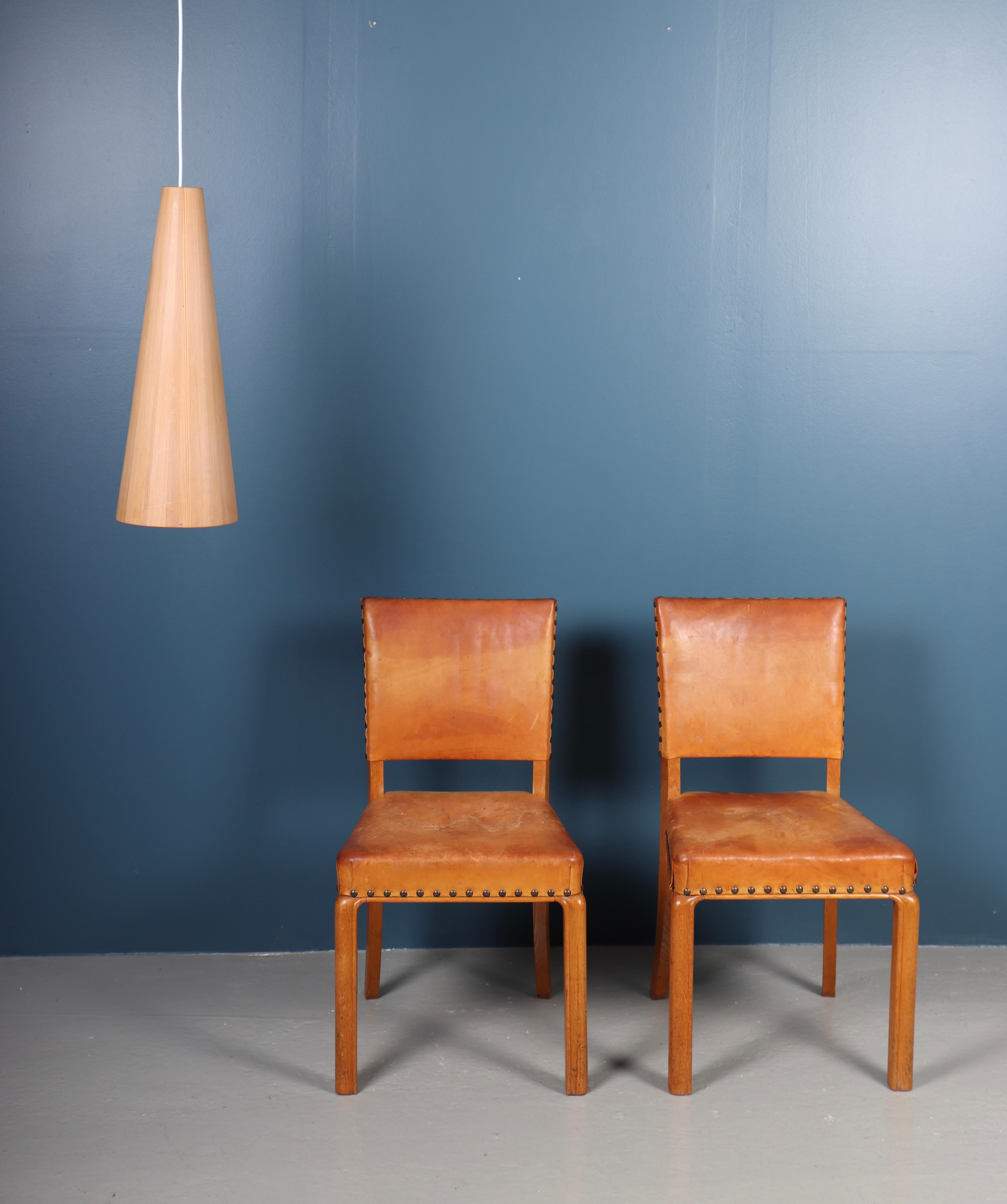 Pair of side chairs in patinated leather and oak. Designed and made in Denmark, great original condition.