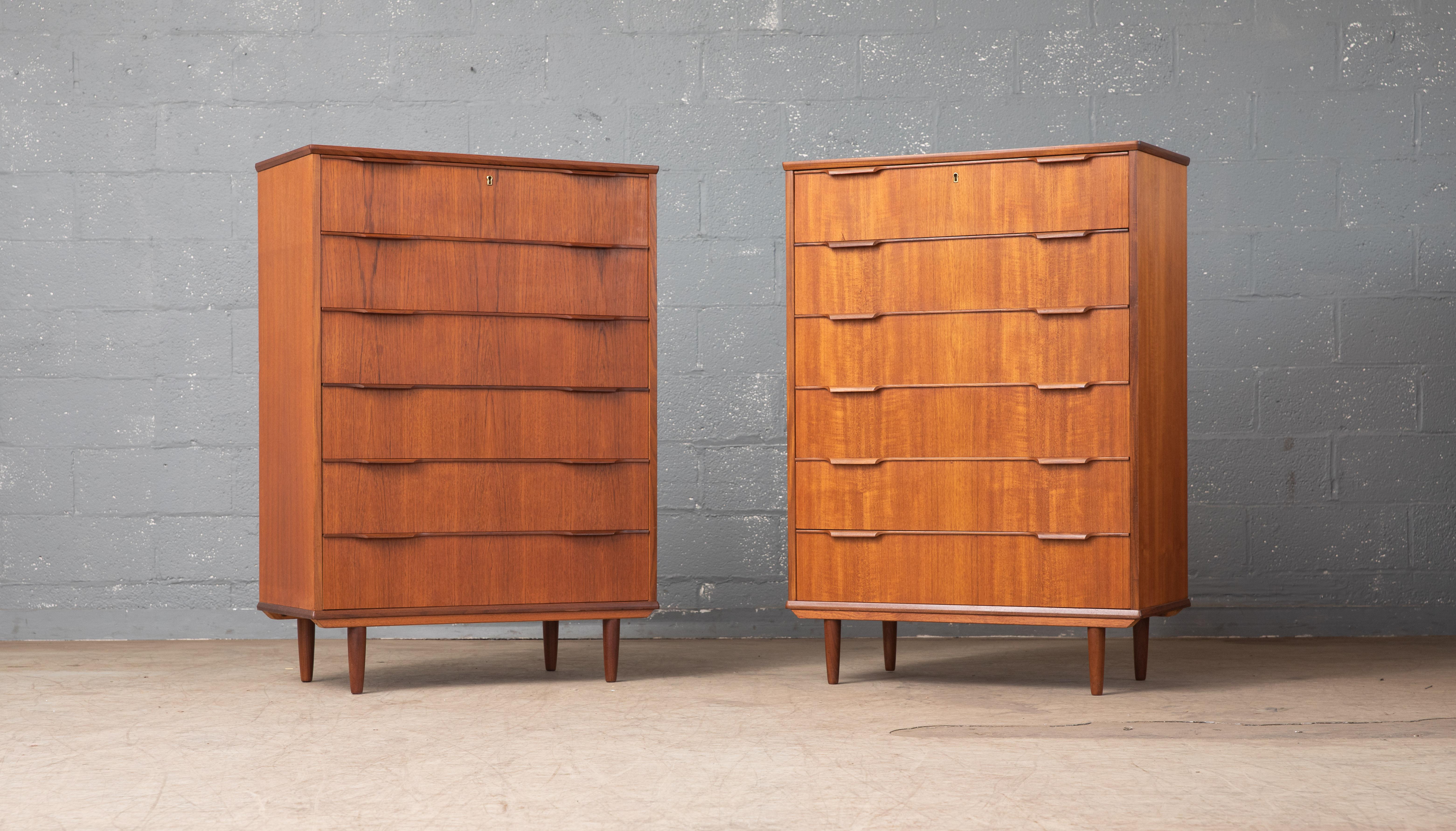 Beautiful Danish 1960s teak tall dresser or chest or drawers in the style of Kai Kristiansen. Sharp distinct design lines. Teak veneer with edges of solid teak and pulls carved from solid teak raised on solid tapered teak legs. Drawers made from