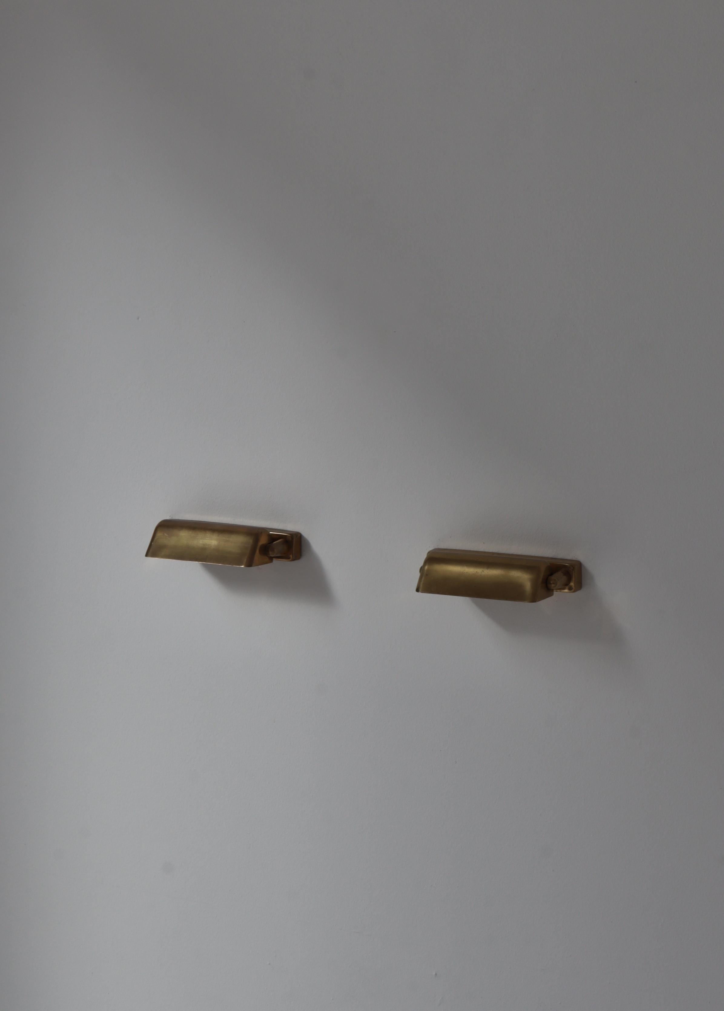 Juego de 2 apliques LYFA fabricados en Dinamarca en la década de 1950. Todo original en latón patinado y lacado en blanco en el interior. Las lámparas tienen una pantalla redondeada ajustable y pueden girar casi 180 grados para iluminar hacia arriba