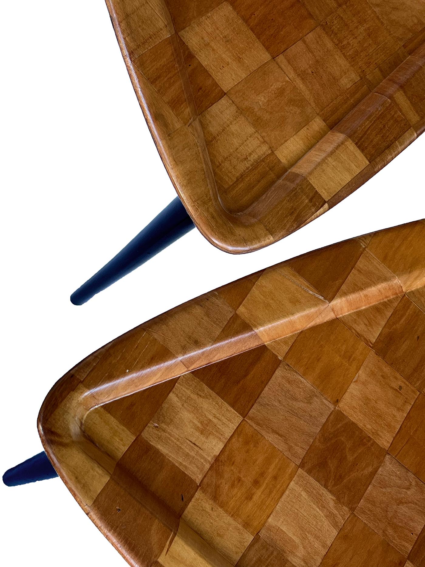 each of triangular form with molded edge composed of square parquetry design; raised on turned tapering ebonized supports