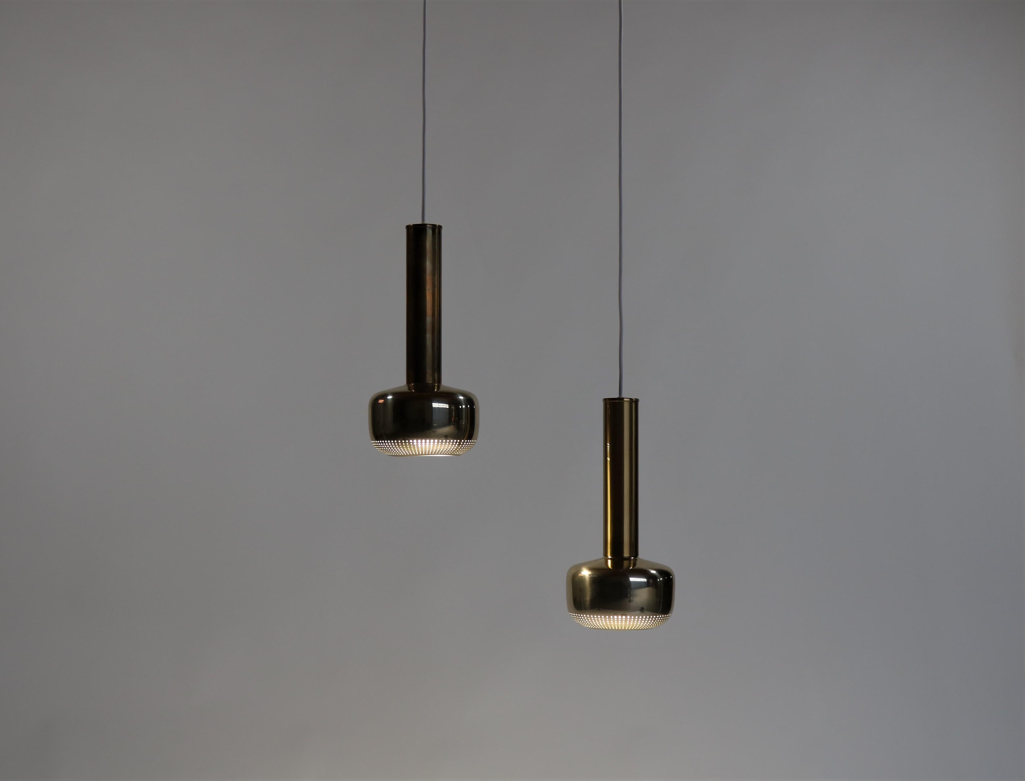 These amazing pendants was designed by Vilhelm Lauritzen in the 1950s and produced by Louis Poulsen. The neck is solid brass while the perforated reflector is made from brass lacquered aluminium. The model was named 