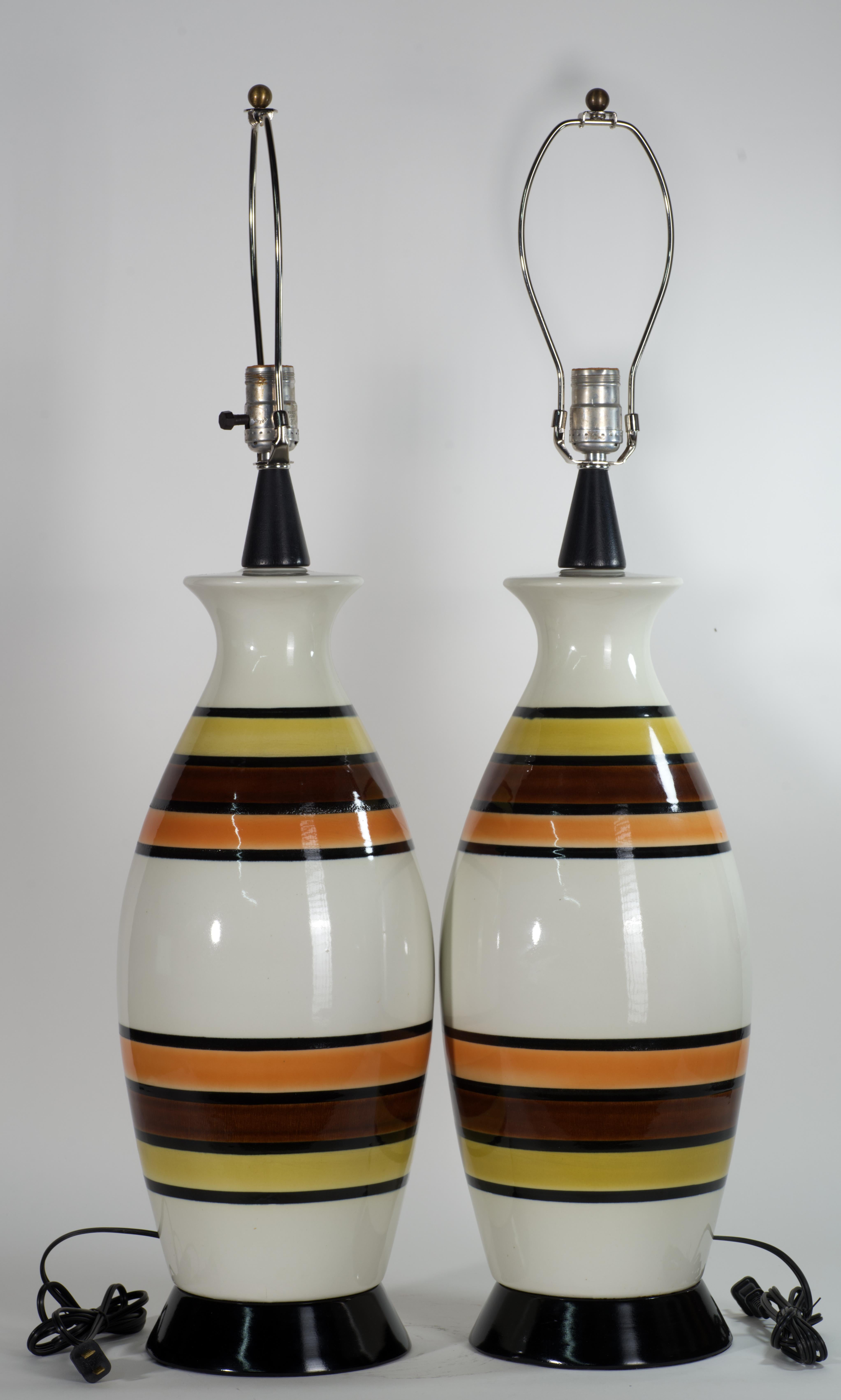  Pareja vintage de lámparas de cerámica de estilo escandinavo moderno danés, con grandes cuerpos de cerámica, bases redondas de metal negro y tapas de madera ebonizada. Los altos y esculturales cuerpos de cerámica blanca están decorados con rayas