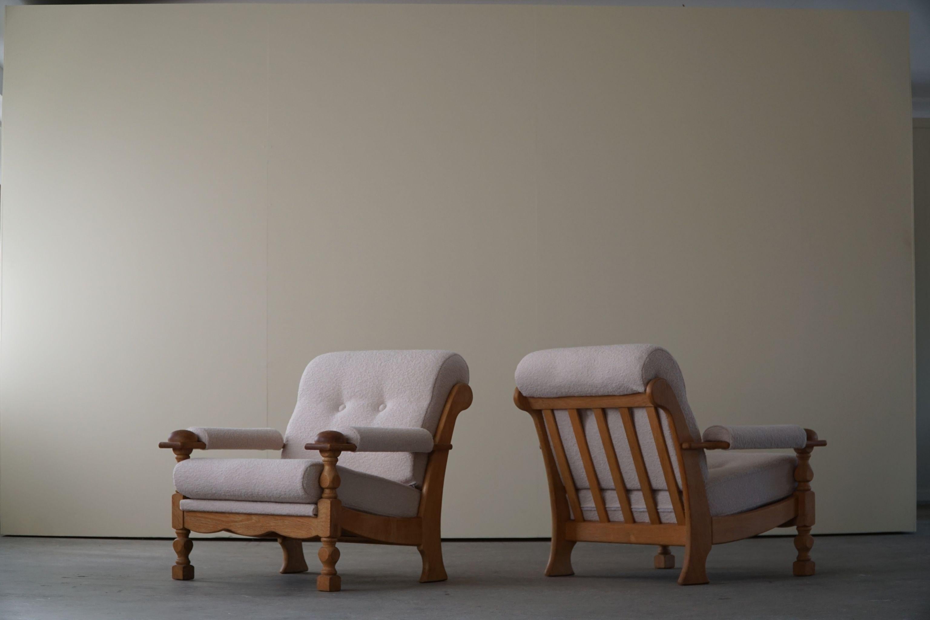 A fascinating sculptural pair of Danish modern lounge chairs in the style of Henning (Henry) Kjærnulf. Made in solid oak and reupholstered in a luxurious Bouclé, Tiree 1002 (Sand) from BUTE fabric. Made in 1960s by a Danish Cabinetmaker with a great