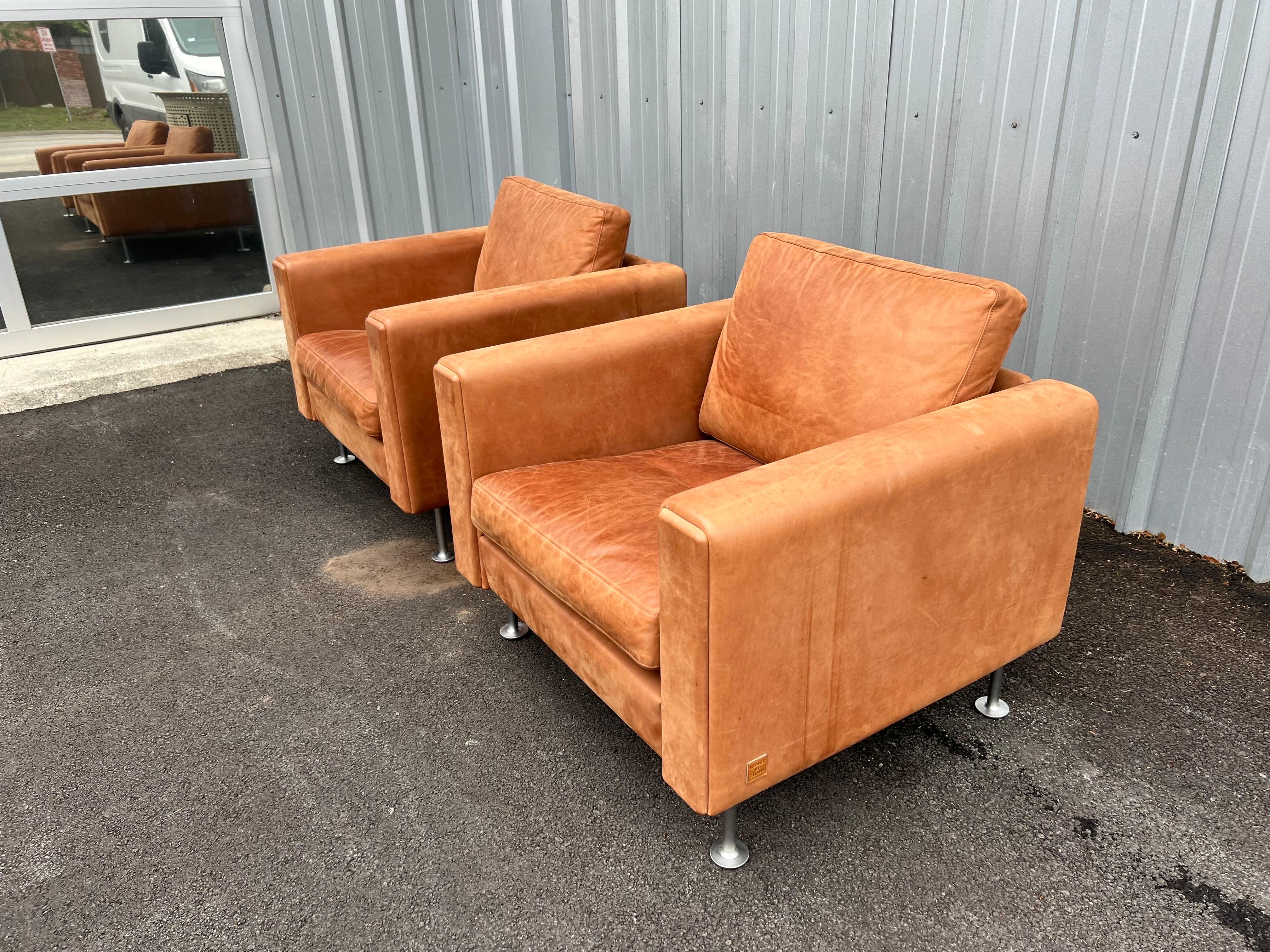 Stunning pair of Danish modern Hans Wegner for Getama, Century 2000 lounge chairs are in a cognac color with steel legs and made in 2018. This design was one of Wegner’s final works. The Century 2000 chairs are hand built at Getama’s factory in