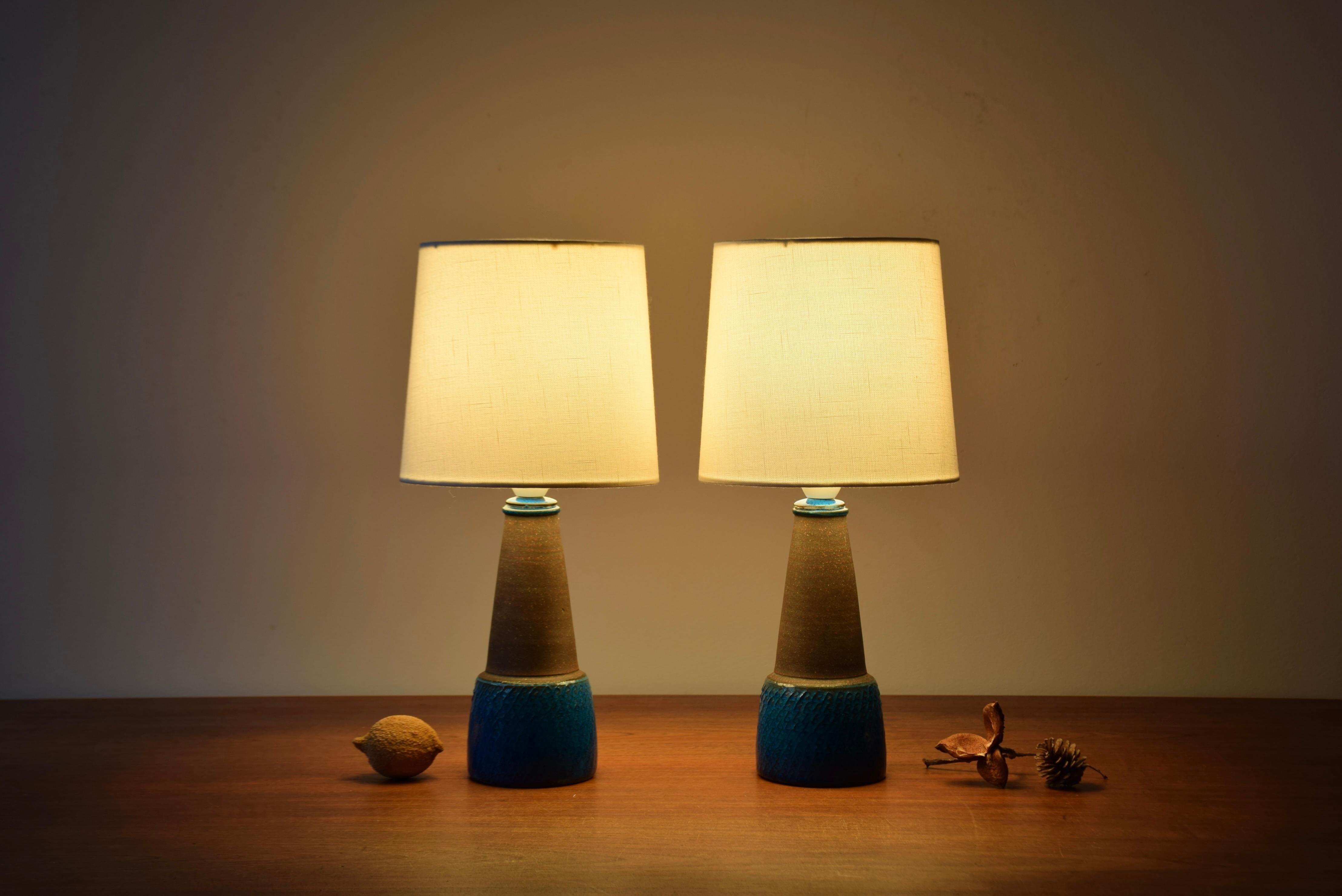 Rare paire de petites lampes de table danoises du milieu du siècle dernier de l'atelier de céramique Kähler (HAK). Le design est attribué à Nils Kähler et ils ont été fabriqués vers les années 1960.

Les lampes sont décorées d'une glaçure bleu