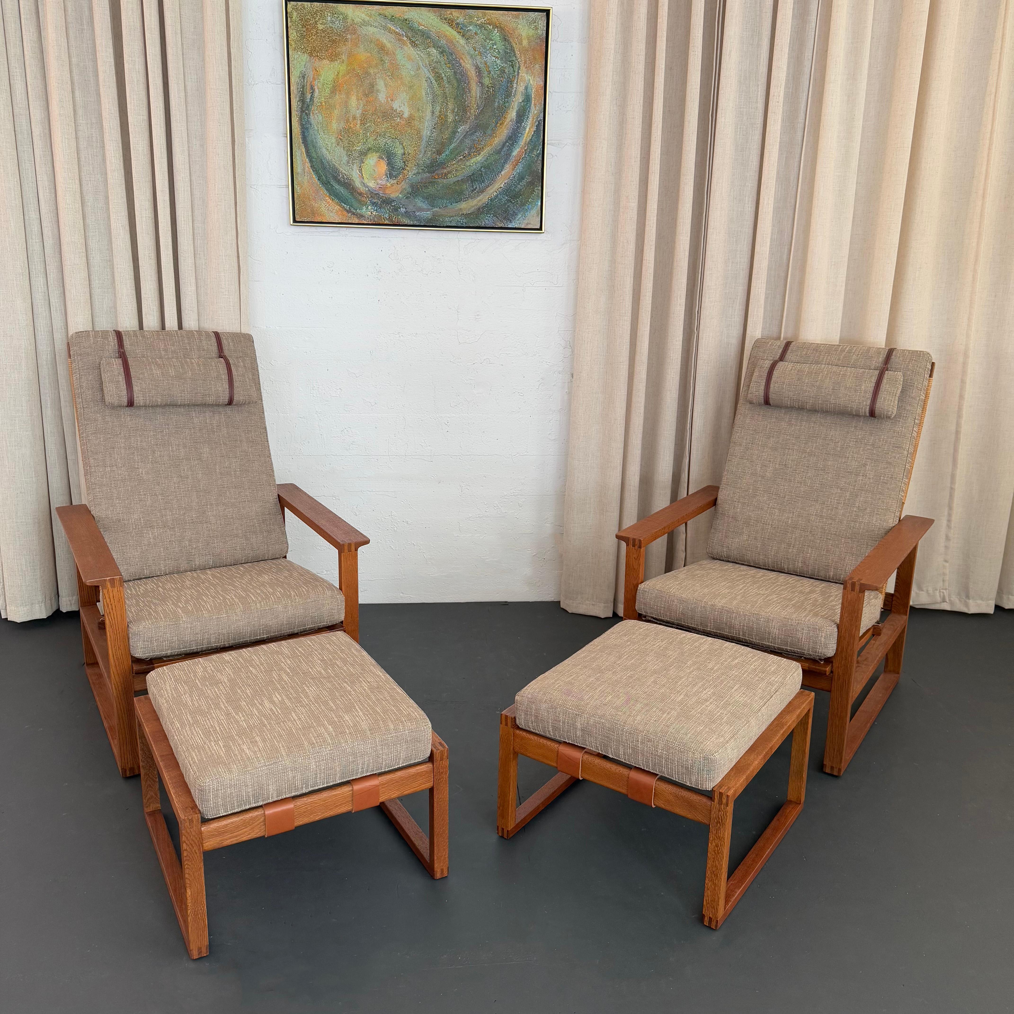 This pair of the Scandinavian Modern upholstered high back lounge chairs (model Slædestolen BM-2254) with matching ottomans were designed by Danish designer Børge Mogensen for Fredericia Stolefabrik in Denmark circa 1956. The oak lounge chairs