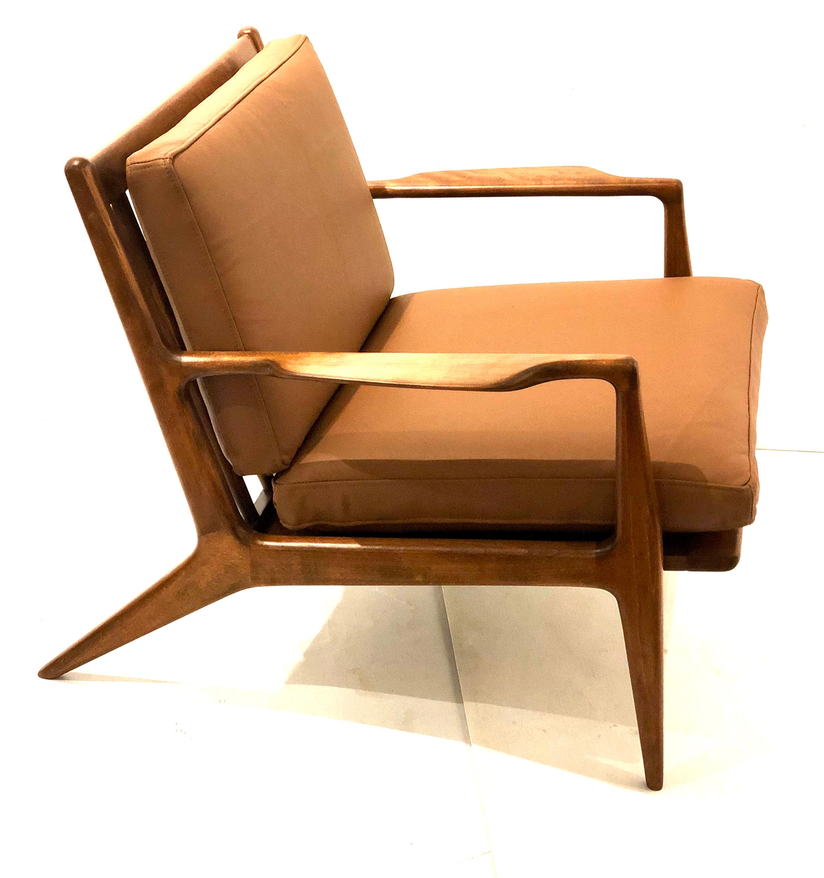 Beautiful pair of elegant chairs designed by Ib Kofod-Larsen for Selig, circa 1950s made in Denmark , freshly refinished in walnut finish and leather cushions new straps ,solid and sturdy very good looking chairs nice sculpted arms with its original
