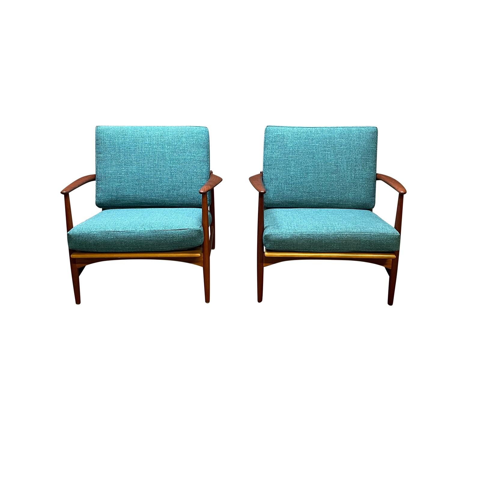 Pair of Danish lounge chairs designed by Kofod Larsen and manufactured by Selig in Denmark, 1960's. This pair features beautiful tapered arm rests, curved sculptured back, brand new teal cushions, upholstery and strapping all on a solid teak frame.