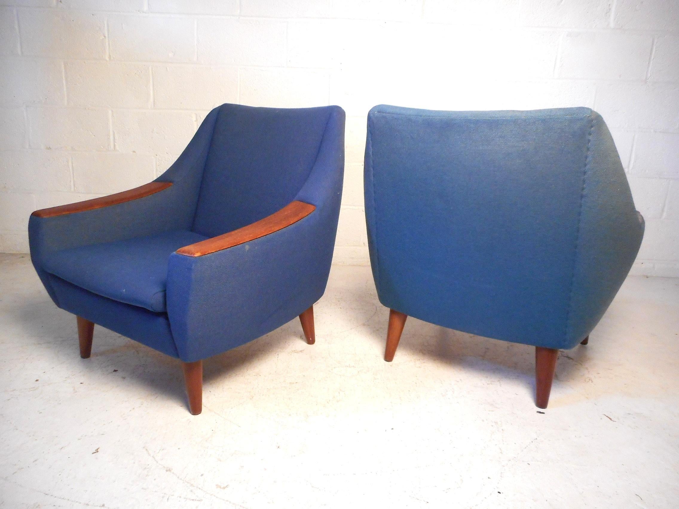 Dieses beeindruckende Paar moderner dänischer Stühle zeichnet sich durch elegant abgeschrägte Rücken- und Armlehnen aus, die den Stühlen ein einzigartiges optisches Profil verleihen. Stilvoll verarbeitete Holzspitzen an den Armlehnen und robuste,