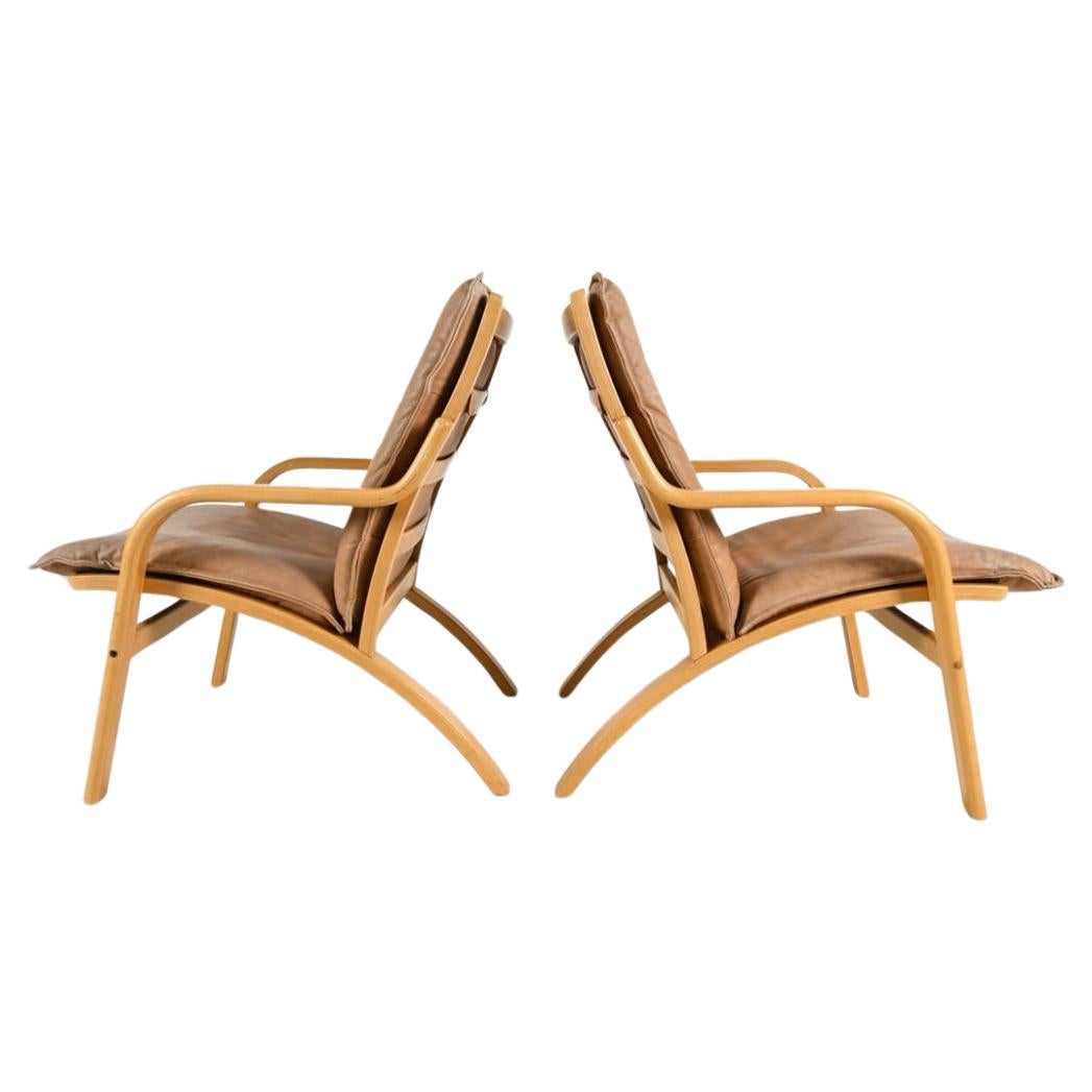 Pair of Danish Modern lounge chairs in bent beech wood and tan leather by Stouby For Sale