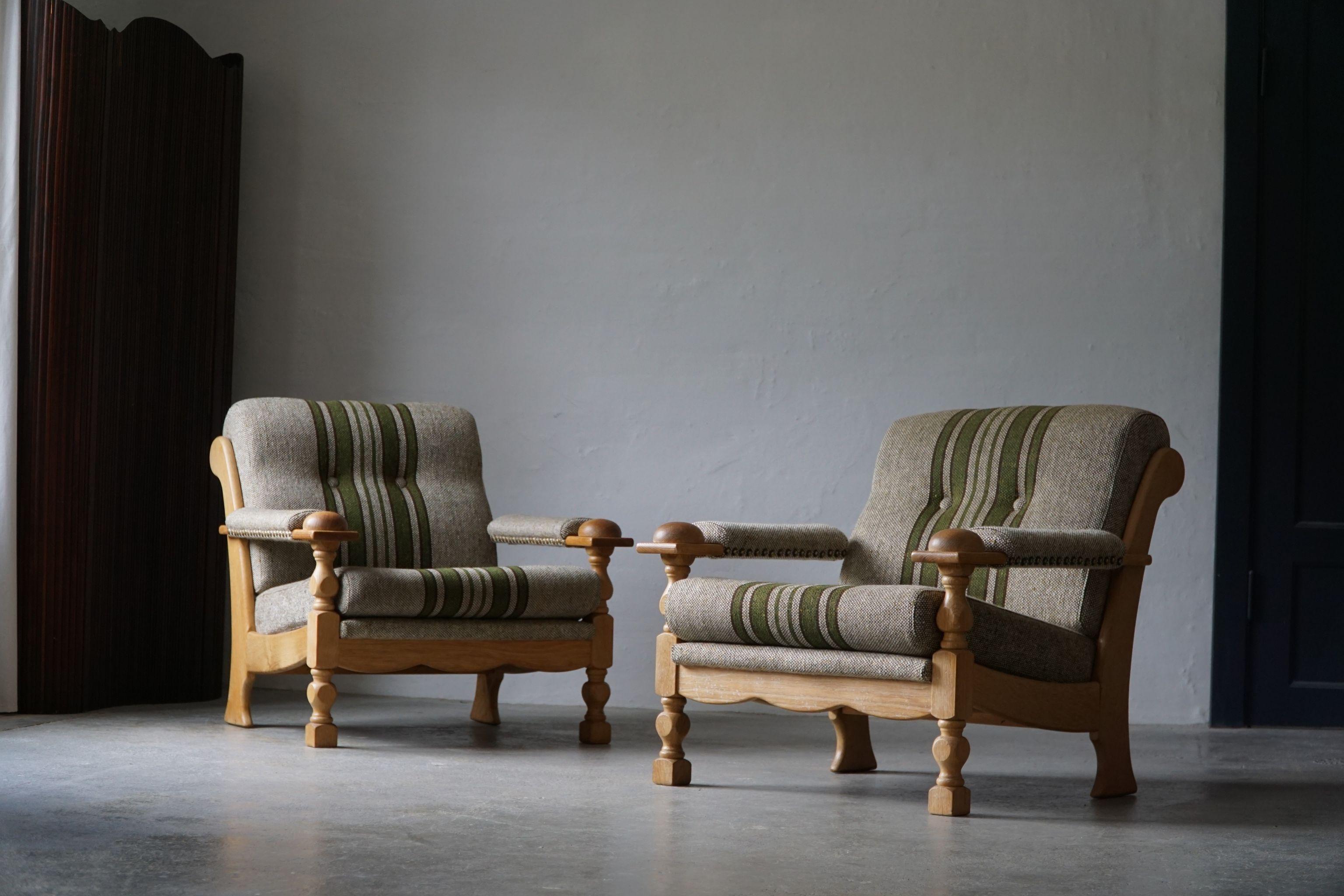 A sculptural pair of Danish Modern lounge chairs in style of Henning Kjærnulf. Made in oak and wool. Made in 1970s by a Danish Cabinetmaker.
The armchairs are in a good original vintage condition. Small marks on the fabric.

These nice vintage