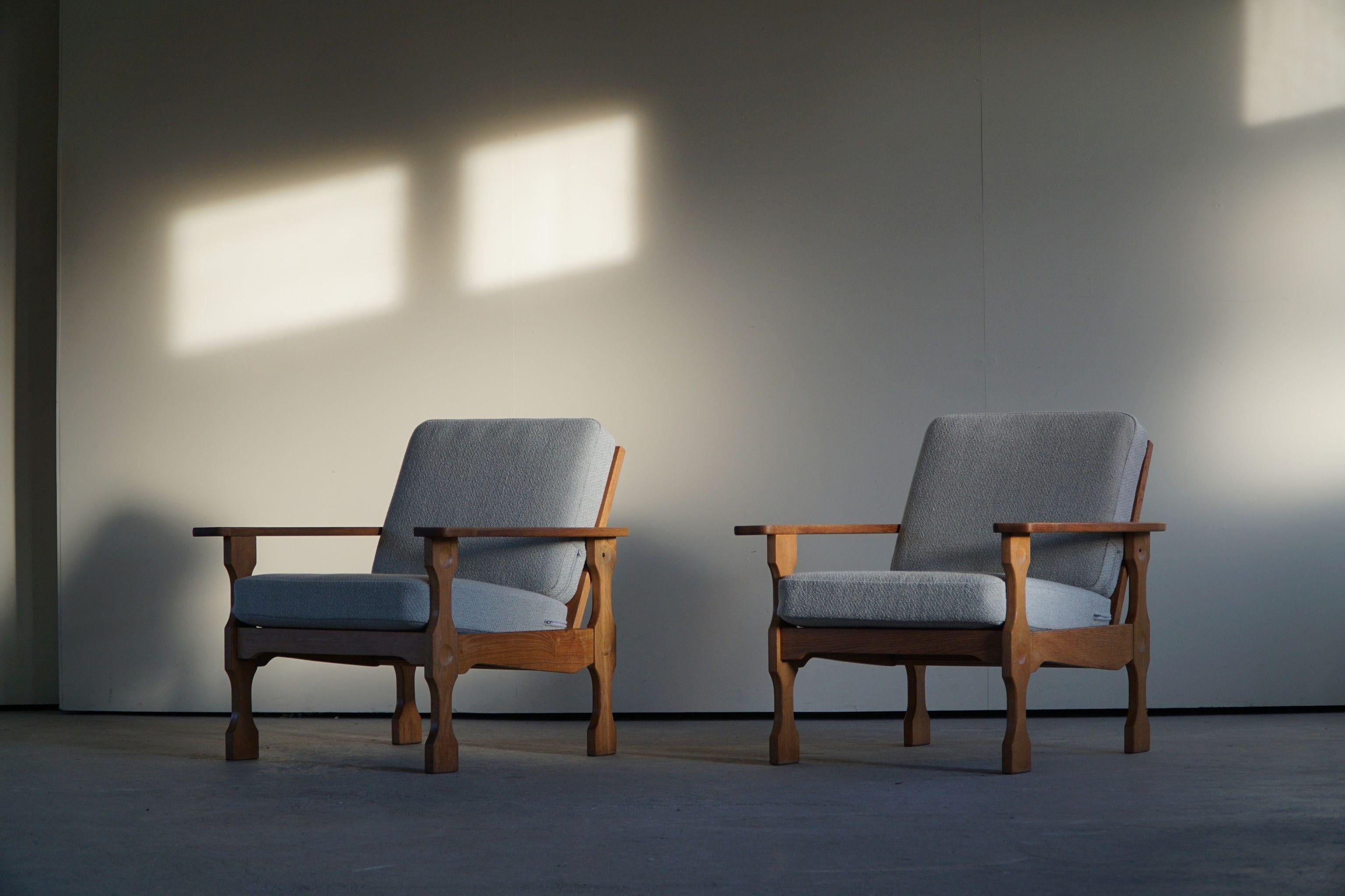 A rare sculptural pair of Danish modern lounge chairs in the style of Henning Kjærnulf. Made in oak and reupholstered in a fine wool. Made in 1960s by a Danish Cabinetmaker. The general impression is really good. 

This nice brutalist pair will