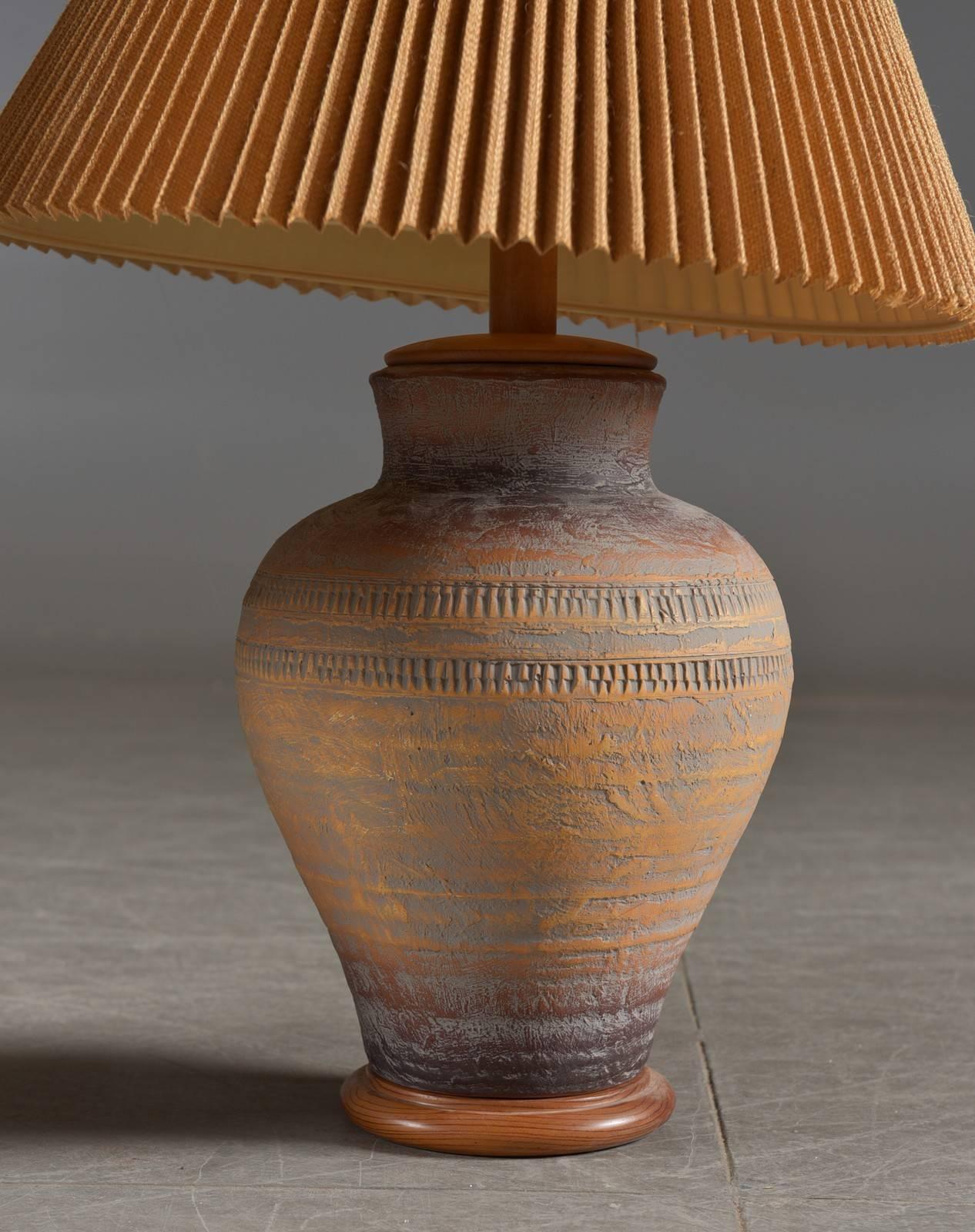 Pair of Danish modern pottery lamps with incised decoration and mounted on wooden bases.