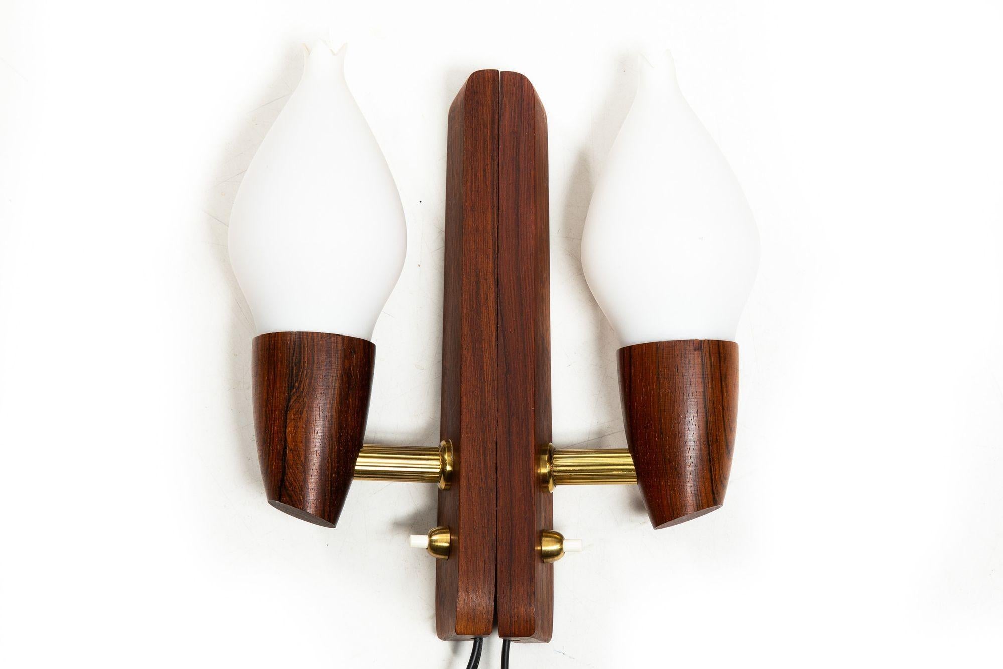 PAIR OF DANISH MODERN ROSEWOOD AND FROSTED-GLASS WALL SCONCES
With original label on the back for Vitrika, Denmark
Item # 311VNK02P

A very sleek pair of sculpted rosewood wall sconces by the Danish lighting firm Vitrika from the 1970s, they feature
