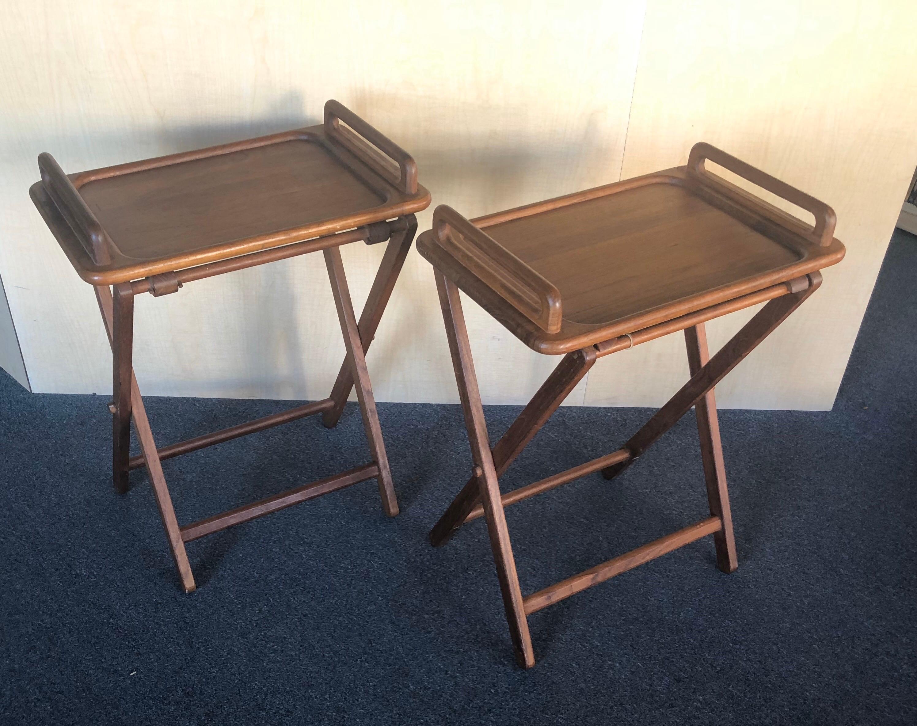 Nice pair of Danish modern solid teak folding TV trays / tray tables, circa 1970s. These trays are portable and hard to find and very desirable. Two solid teak tray with handles that are easy to set up, carry and store.