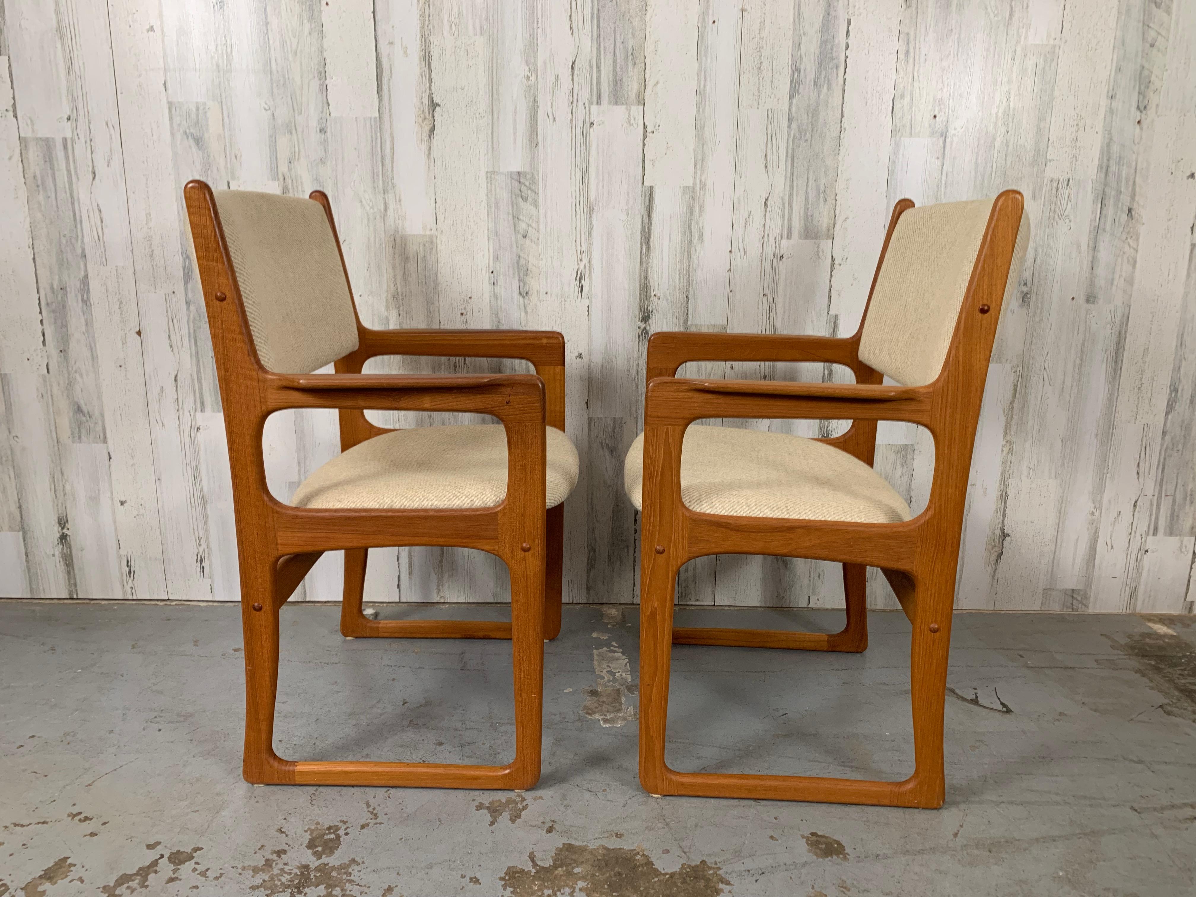 Very comfortable curved back solid teak dining / armchairs in the style of Danish modern.