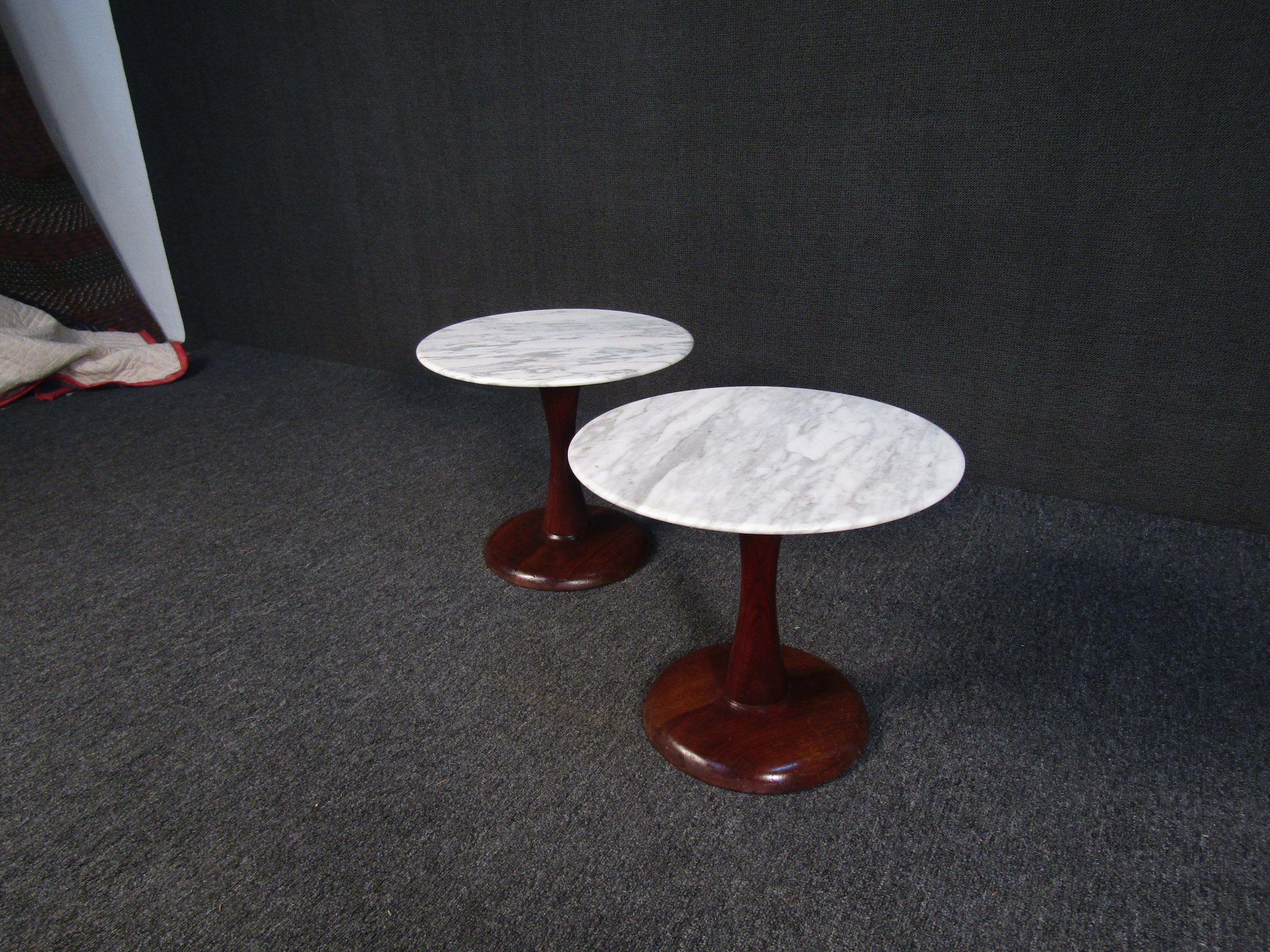 Striking and beautiful pair of vintage end tables in the Danish Modern style. With sculpted walnut bases and round marble tops, this pair of tables is sure to stand out anywhere. Please confirm item location with seller (NY/NJ).