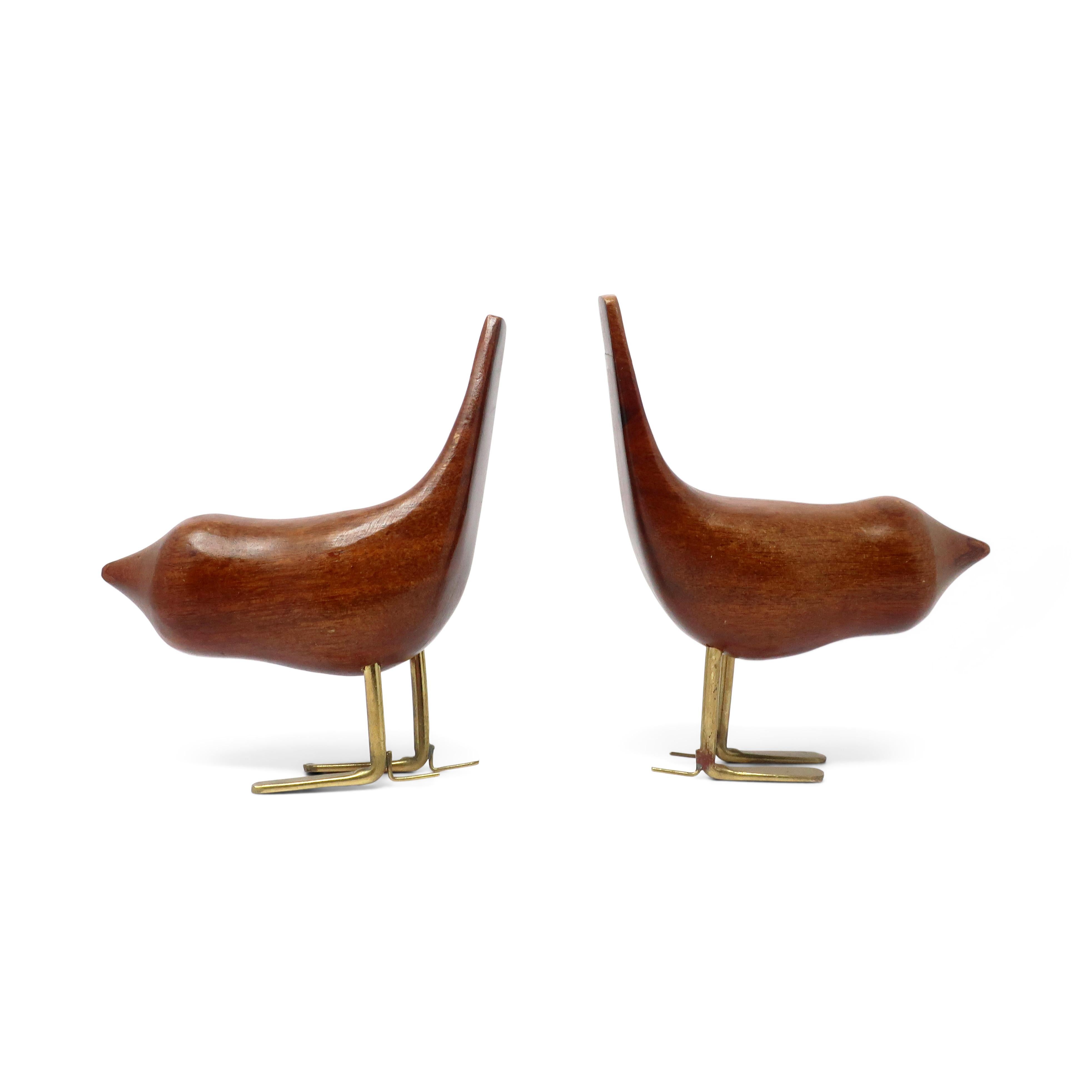 A lovely pair of mid-century modern/Danish Modern teak bird sculptures with metal leg in the style of Jacob Hermann's bird sculptures and Eames' house bird design.

In vintage condition with wear consistent with age, including signs of previous