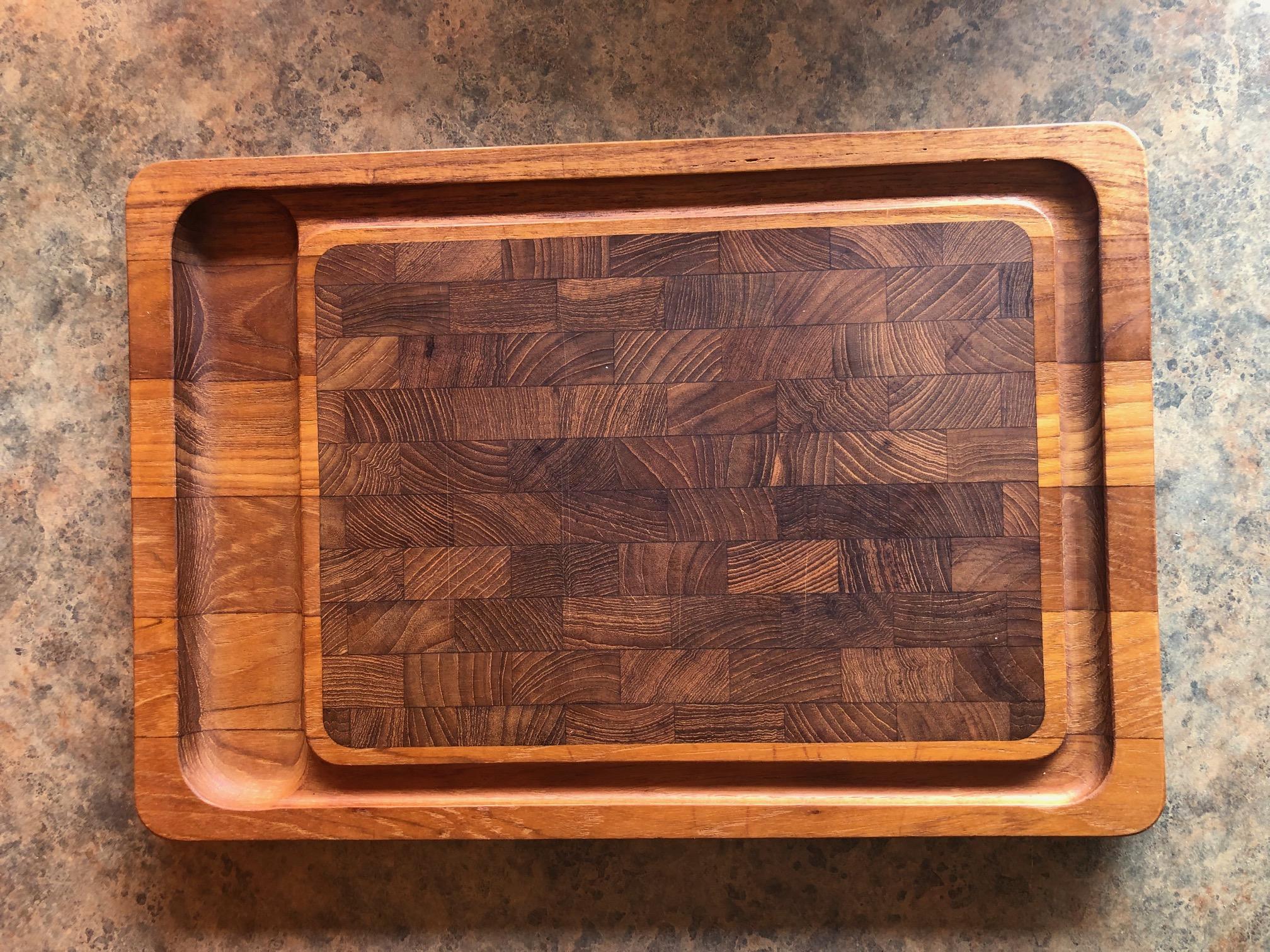 Pair of Danish modern teak butcher block cutting board / tray for cheese with edge by Jens Quistgaard for Dansk, circa 1970s. The rectangle cutting board measures 17.25