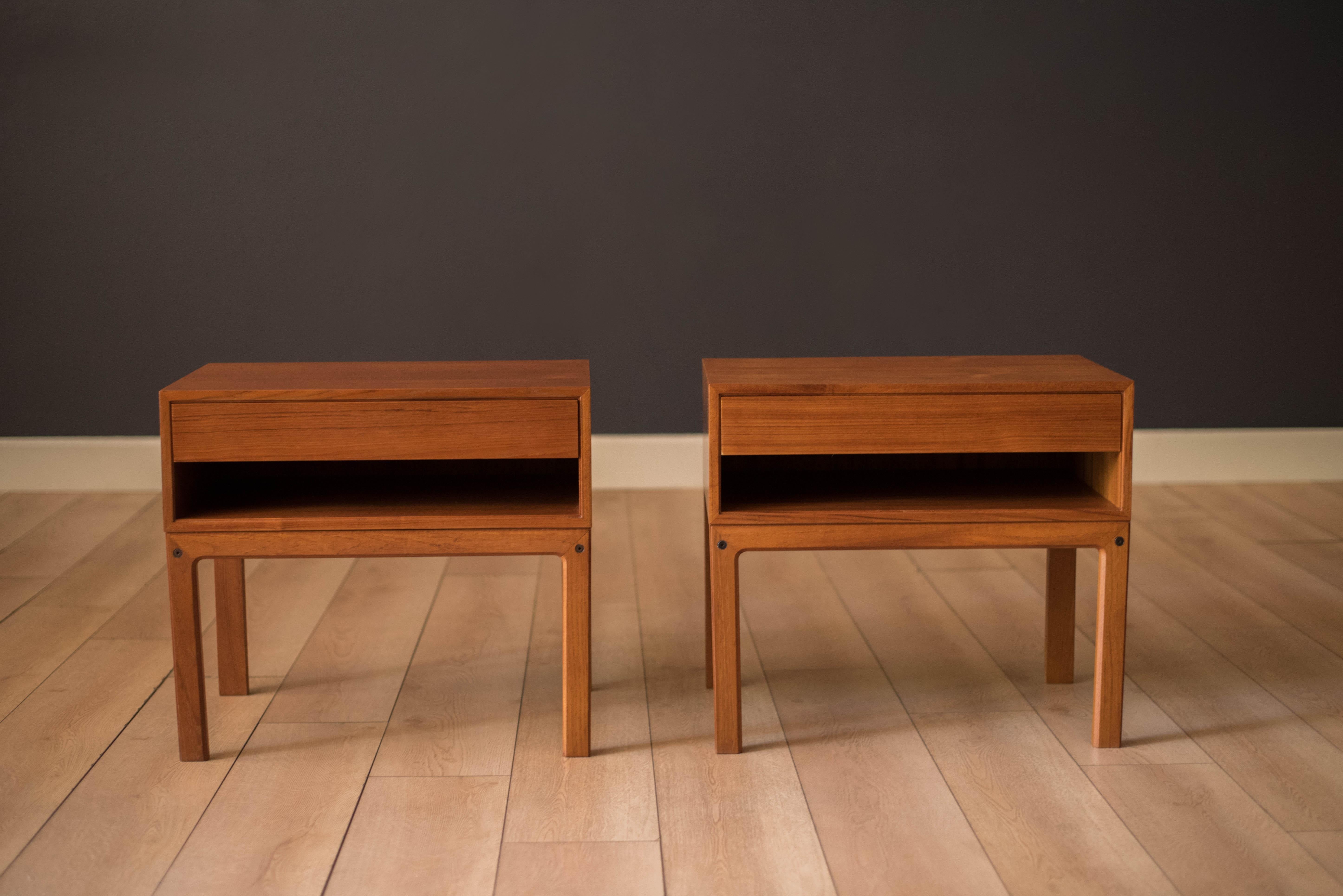Mid century modern pair of bedside table nightstands in teak designed by Arne Wahl Iversen for Vinde Møbelfabrik, circa 1960's. This set features dovetail constructed drawers and an open shelf compartment for extra storage. Price is for the set of