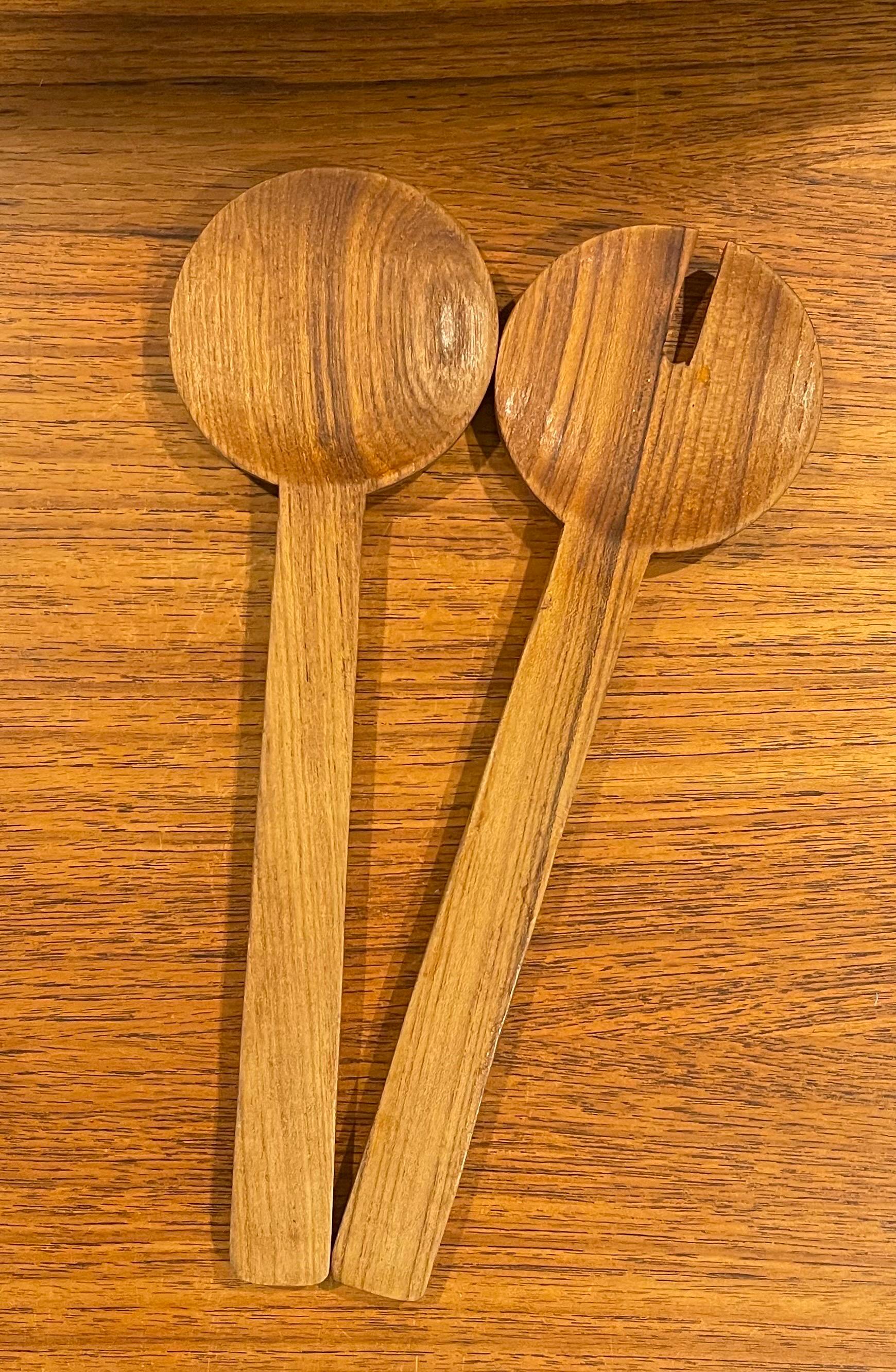 A nice pair of Pair of Danish Modern teak salad servers, circa 1970s. The servers are made of solid teak and they measure 12