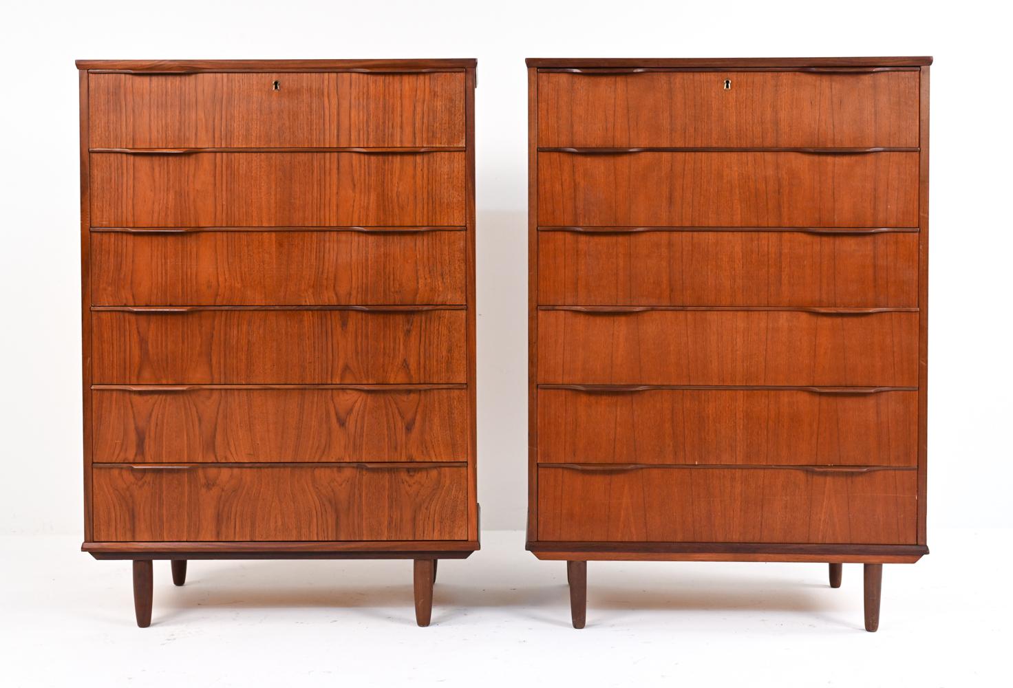 Form and function come together in this pair of tall chests - each with six dovetailed drawers - featuring carved wing- or lip-style handles and rounded tapered legs. Danish, circa 1960's; in the style of Klaus Okholm for Trekanten, Johnson Carper,