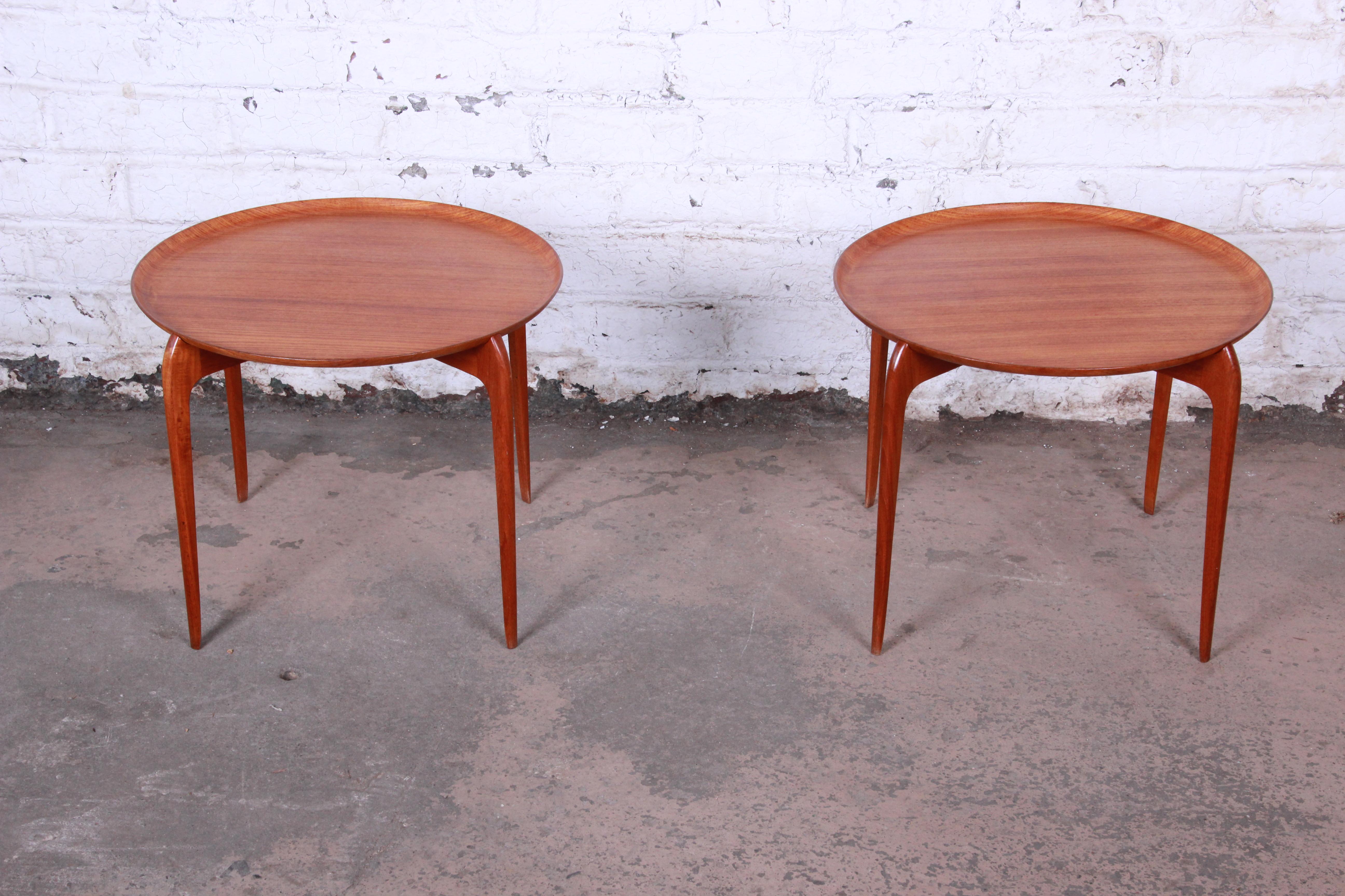 An exceptional pair of Danish Modern teak tray tables by Moreddi. The tables feature gorgeous teak wood grain and unique removable tray tops. Nice sleek, minimalist Danish design. The original Moreddi labels are present on the underside of each