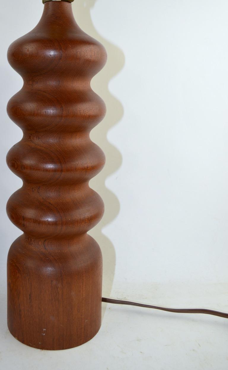 Stylish pair of turned wood table lamps, in clean, original working condition. Although these lamps are identical in design and size, one has a noticeably darker finish than the other, as shown. We are pricing and offering these individually,