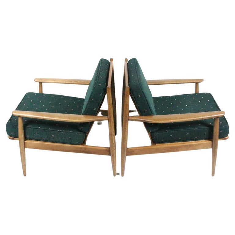 American Mid Century Viko Baumritter attributed Wide Walnut Lounge Chairs. Featuring sturdy framework, angled spindle backs, sculpted solid Oak armrests and dowel legs. With newly upholstered reversible and zippered ribbed Dark Green fabric