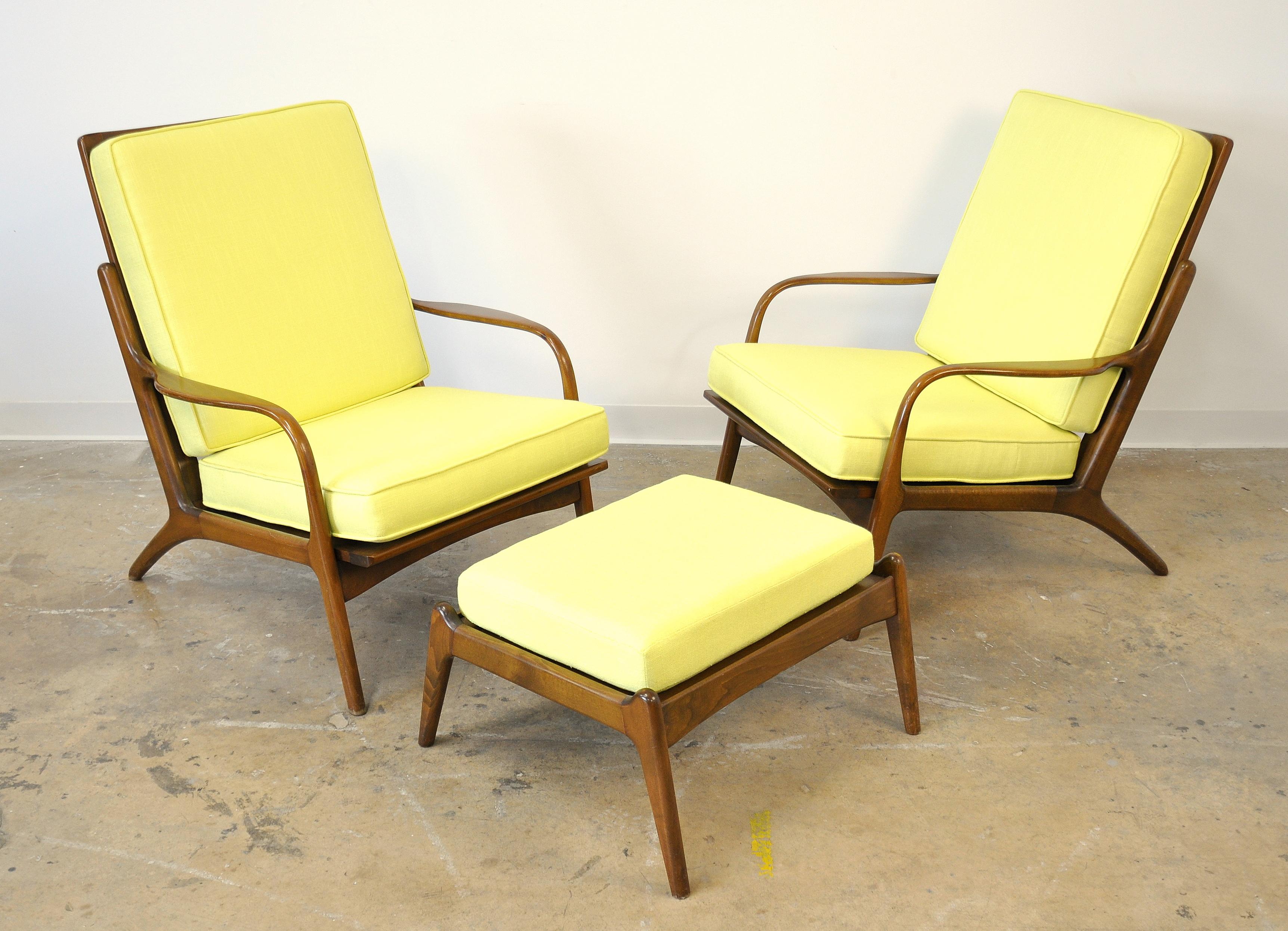 A pair of vintage midcentury high back easy armchairs and foot stool, dating from the 1950s and attributed to designer Ib Kofod-Larsen. The frames of the chairs have sleek, slender arms, a spindle high back and splayed legs. Their lines are very