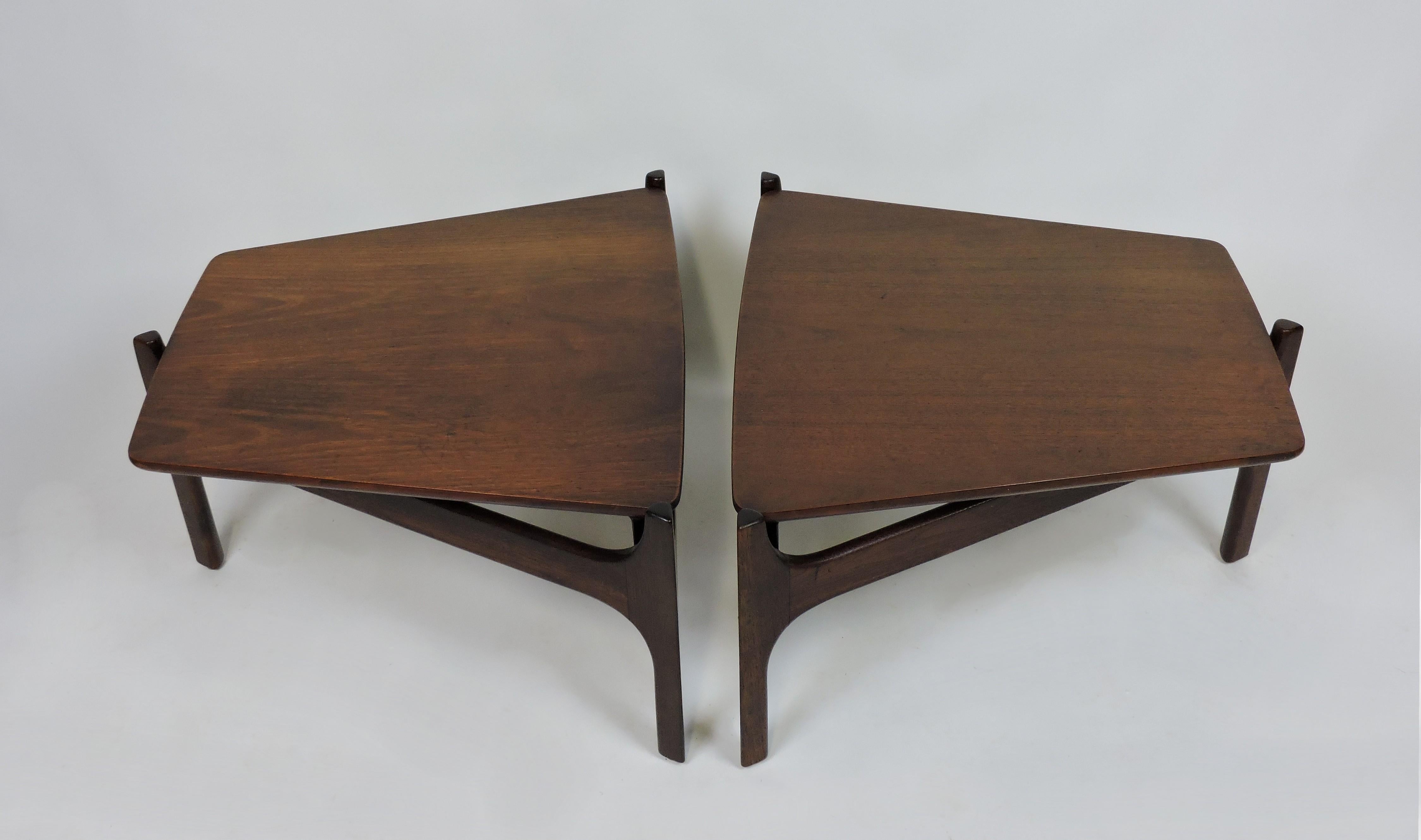 Pair of very cool and rare tables designed by John Keal for Brown Saltman. These tables have a floating trapezoid shaped top that rests on a sculpted solid walnut base with three legs. Originally designed as a modular unit to attach to matching