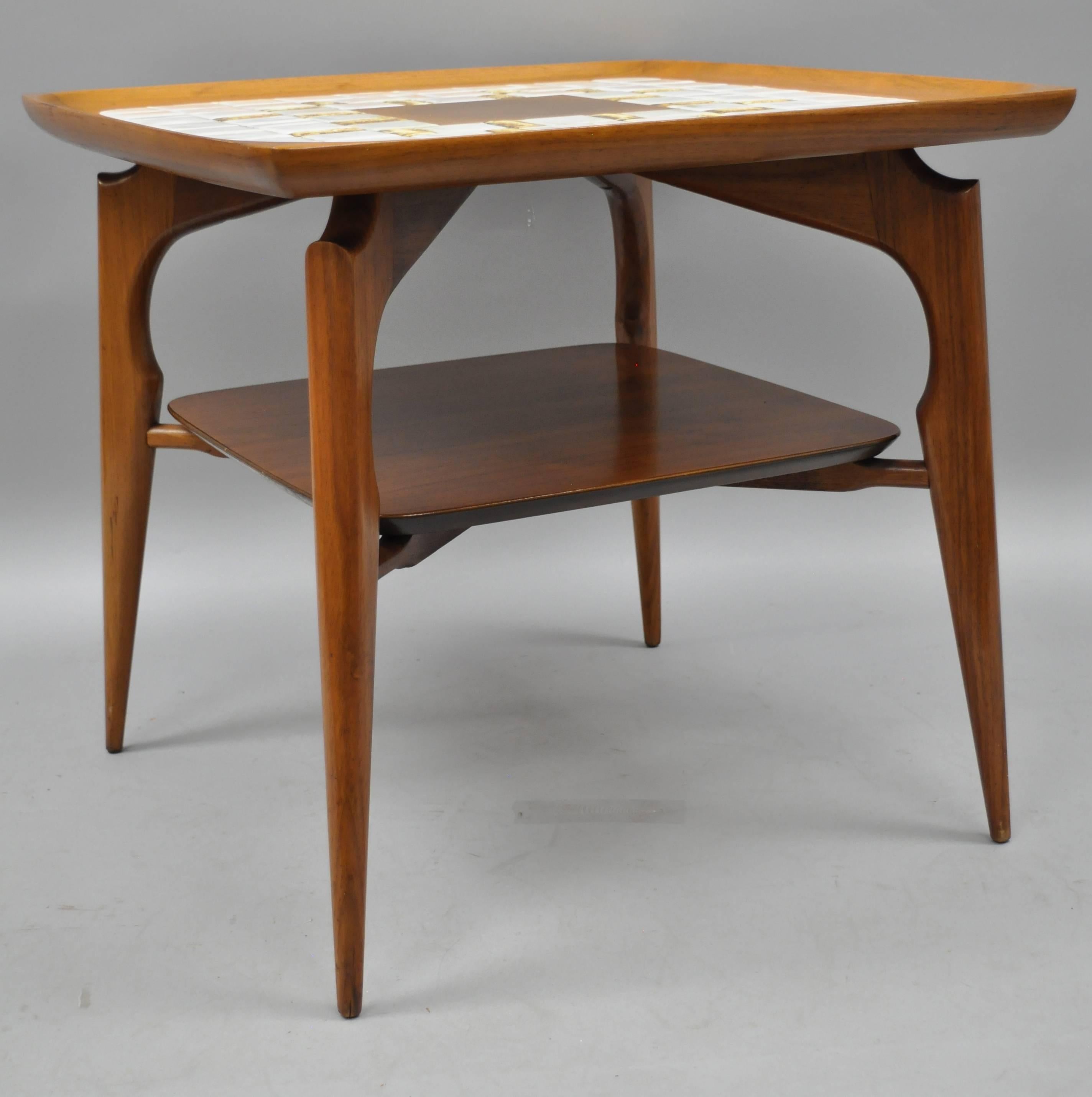 Pair of Danish modern walnut and tile top end tables. Item features mosaic porcelain tile tops, lower shelves, raised and sculpted edges. Solid walnut frames, tapered legs, and sleek sculptural form, circa mid-20th century. Measurements: 23