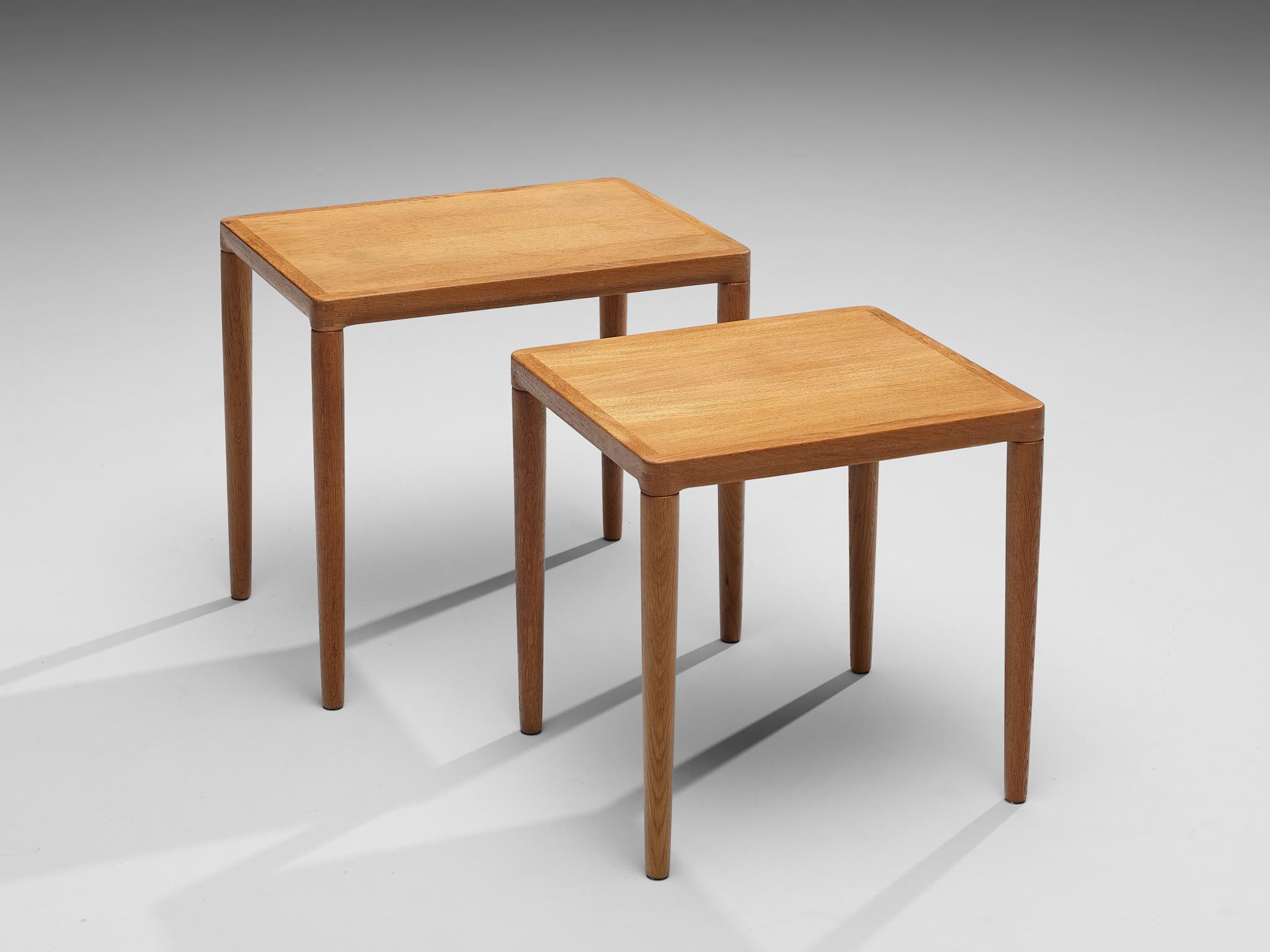 Pair of nesting tables, oak, Denmark, 1950s

On four tapered cylindrical legs the tabletop is resting. The top is framed which adds an almost decorative detail and visually structures the table as well as the wooden connections at the corners are