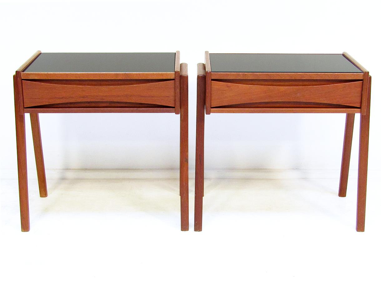 A pair of Danish 1960s teak side tables attributed to Arne Vodder for Sibast.

With sculpted drawer and striking black glass surface, they can be used either as nightstands or sofa tables.

They are in excellent vintage condition.